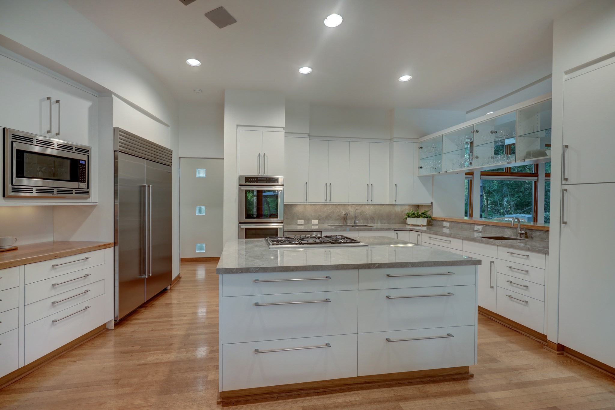 Gourmet Kitchen with top of the line stainless steel appliances, sleek cabinets, moderno Fior Di Bosco porcelain and pecan countertops.
