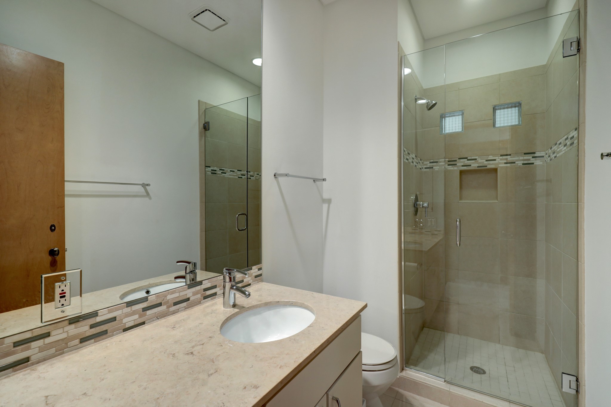 Third bedroom bathroom offers a large counter with undermount sink, a walk in shower with glass enclosure.