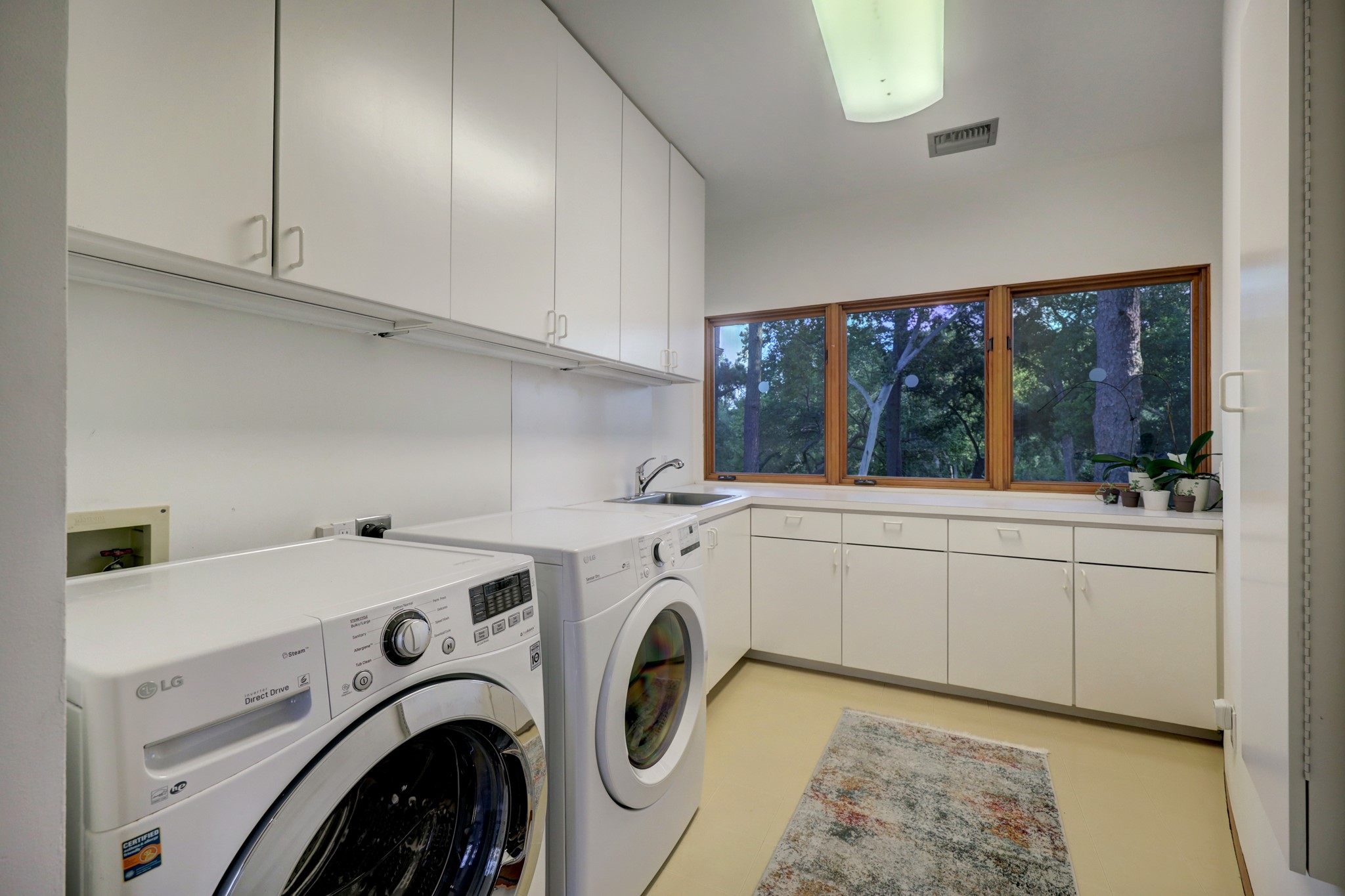 Spacious Laundry area with plenty of cabinets for storage and great views.