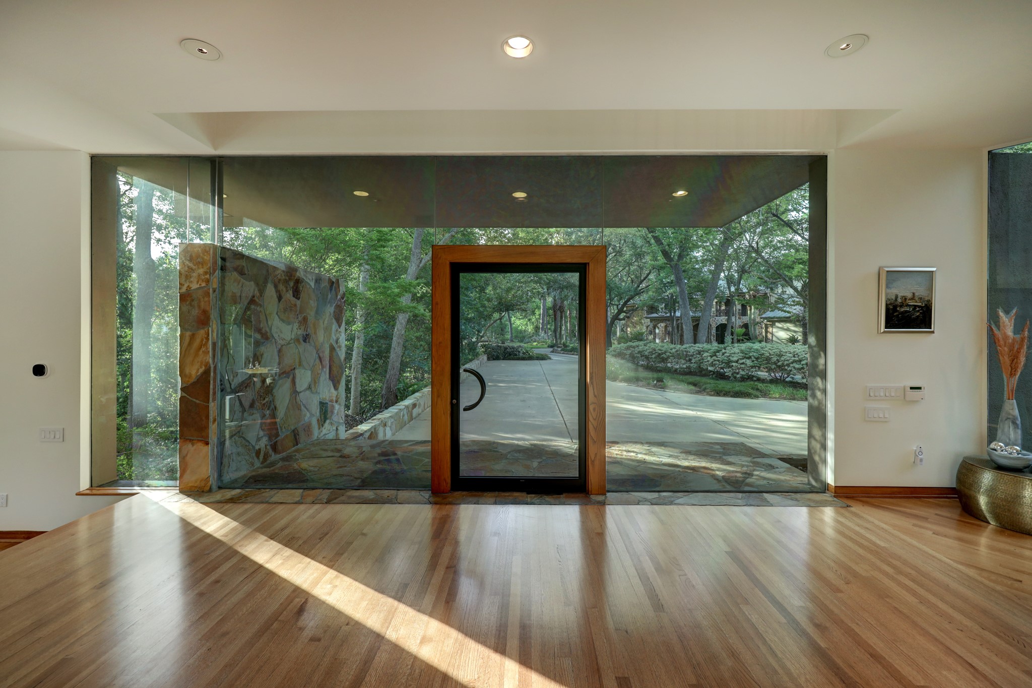 One of a kind glass pivot front door makes the entry remarkable and memorable, it provides a sleek welcome and complements perfectly to the architectural style.