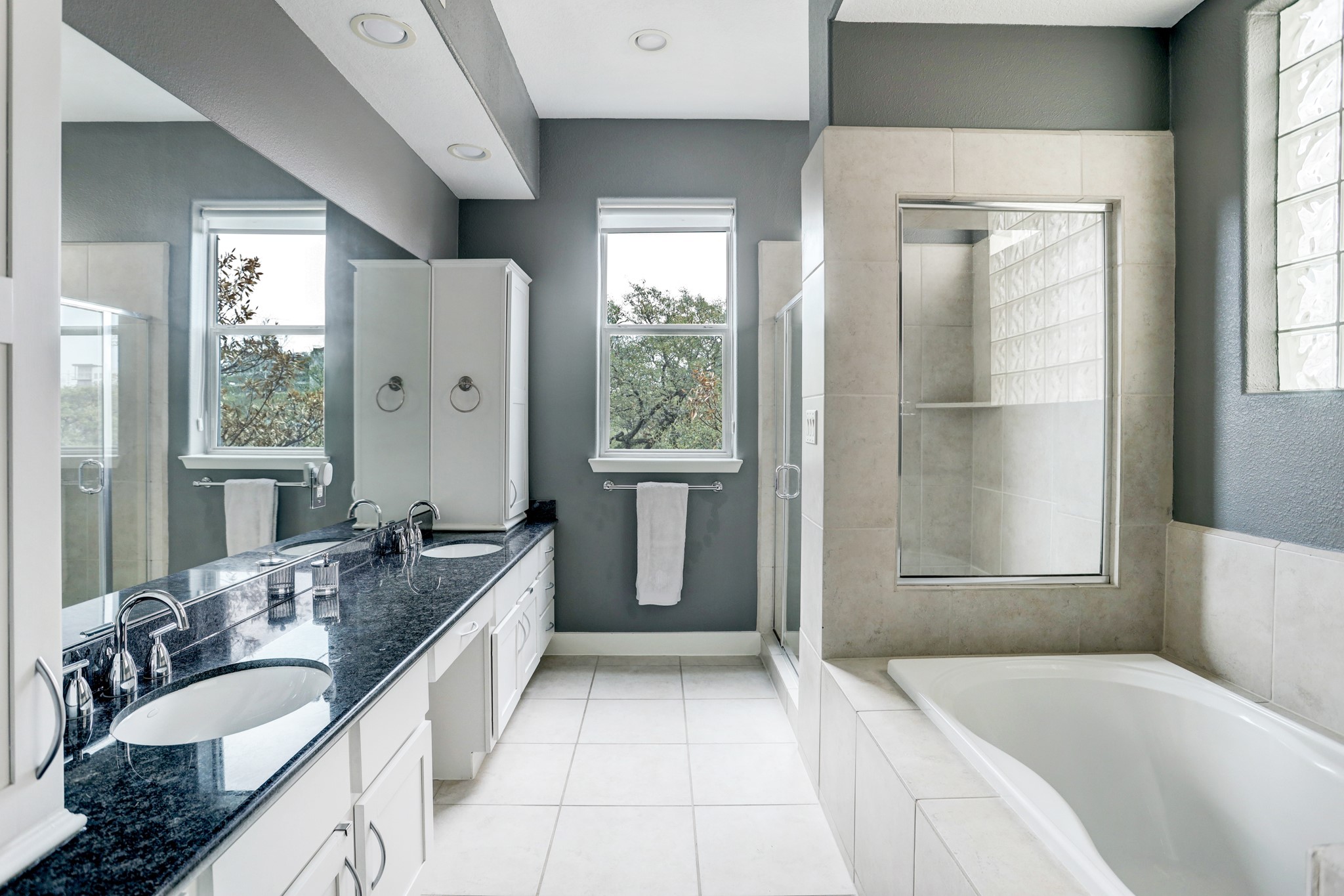 The primary bathroom has double sinks and a vanity, large soaking tub and a large walk-in shower.