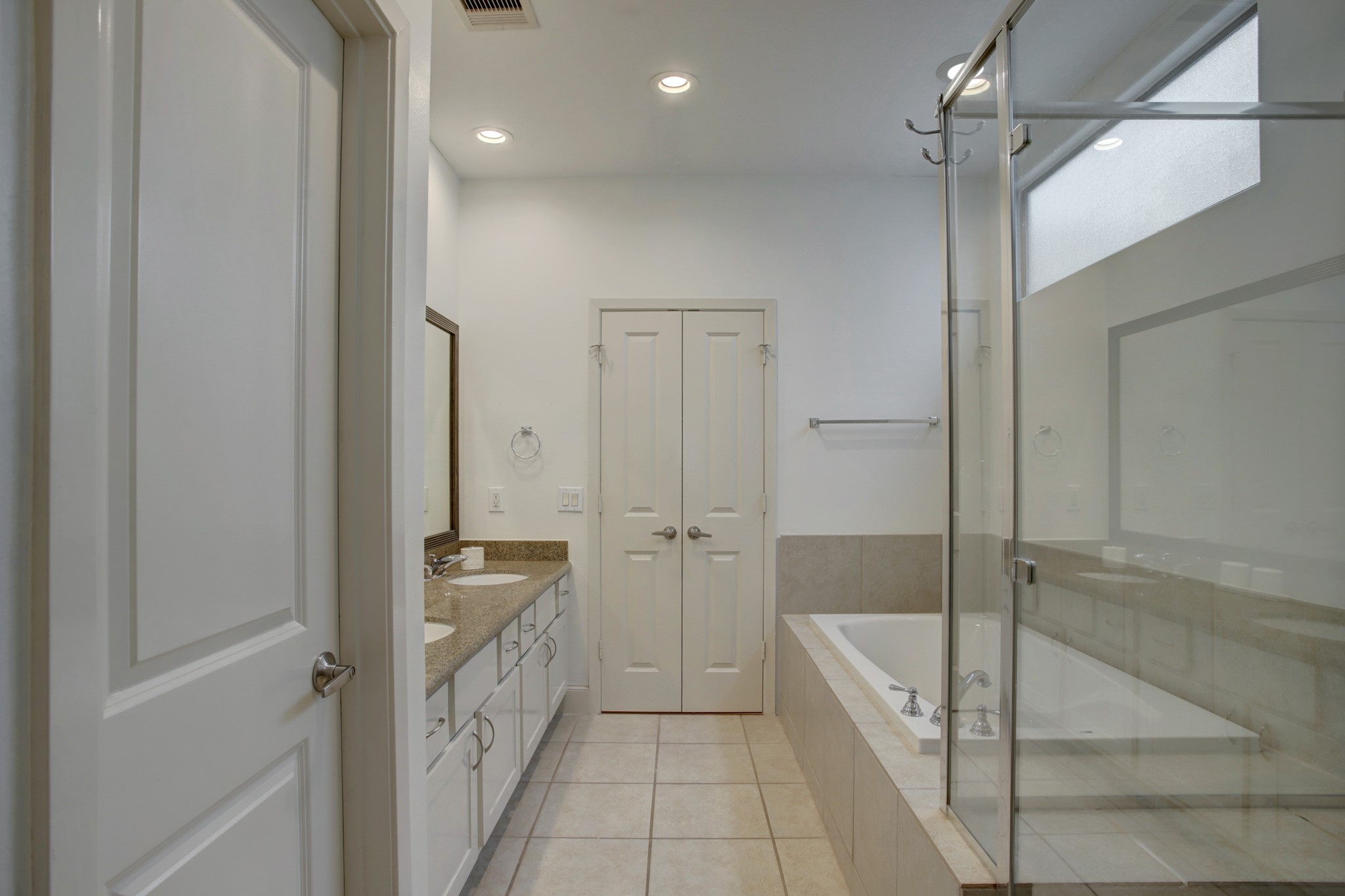 Luxurious primary bath with double sinks, large shower and jetted tub.