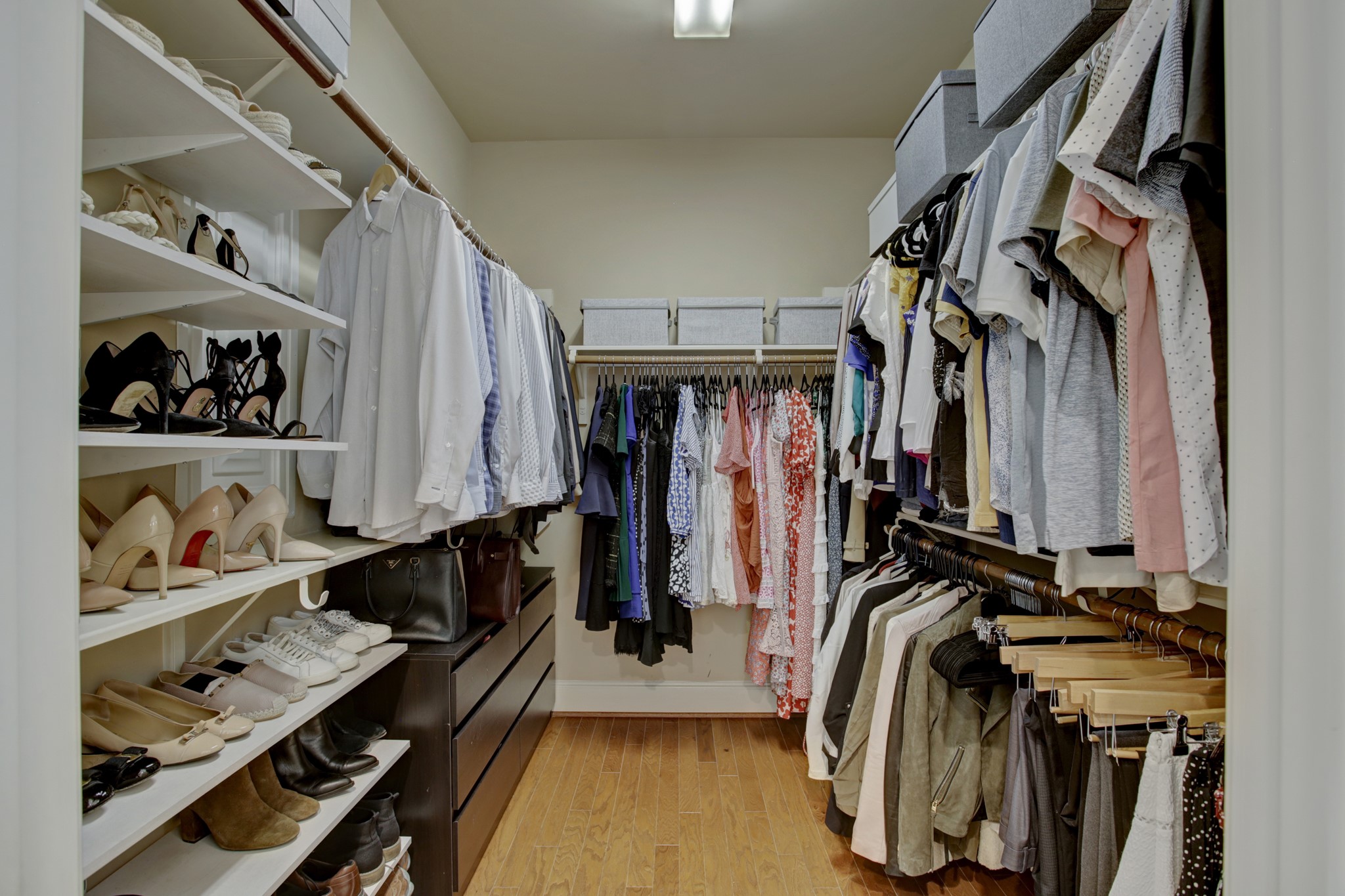 Huge primary closet with abundance of hanging space and built in shelving.