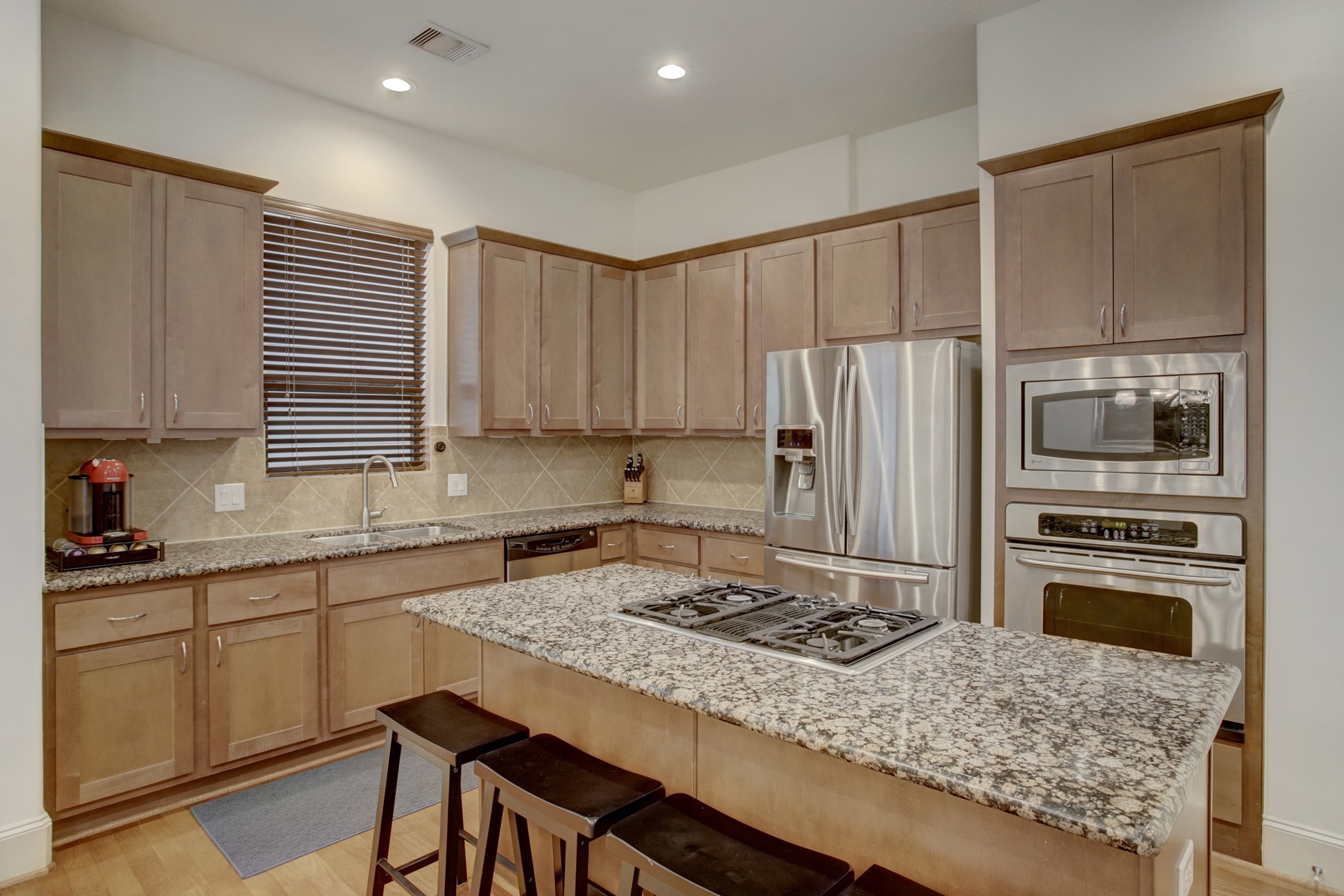Cooks dream kitchen with granite counter tops and all stainless steel appliances including the refrigerator.
