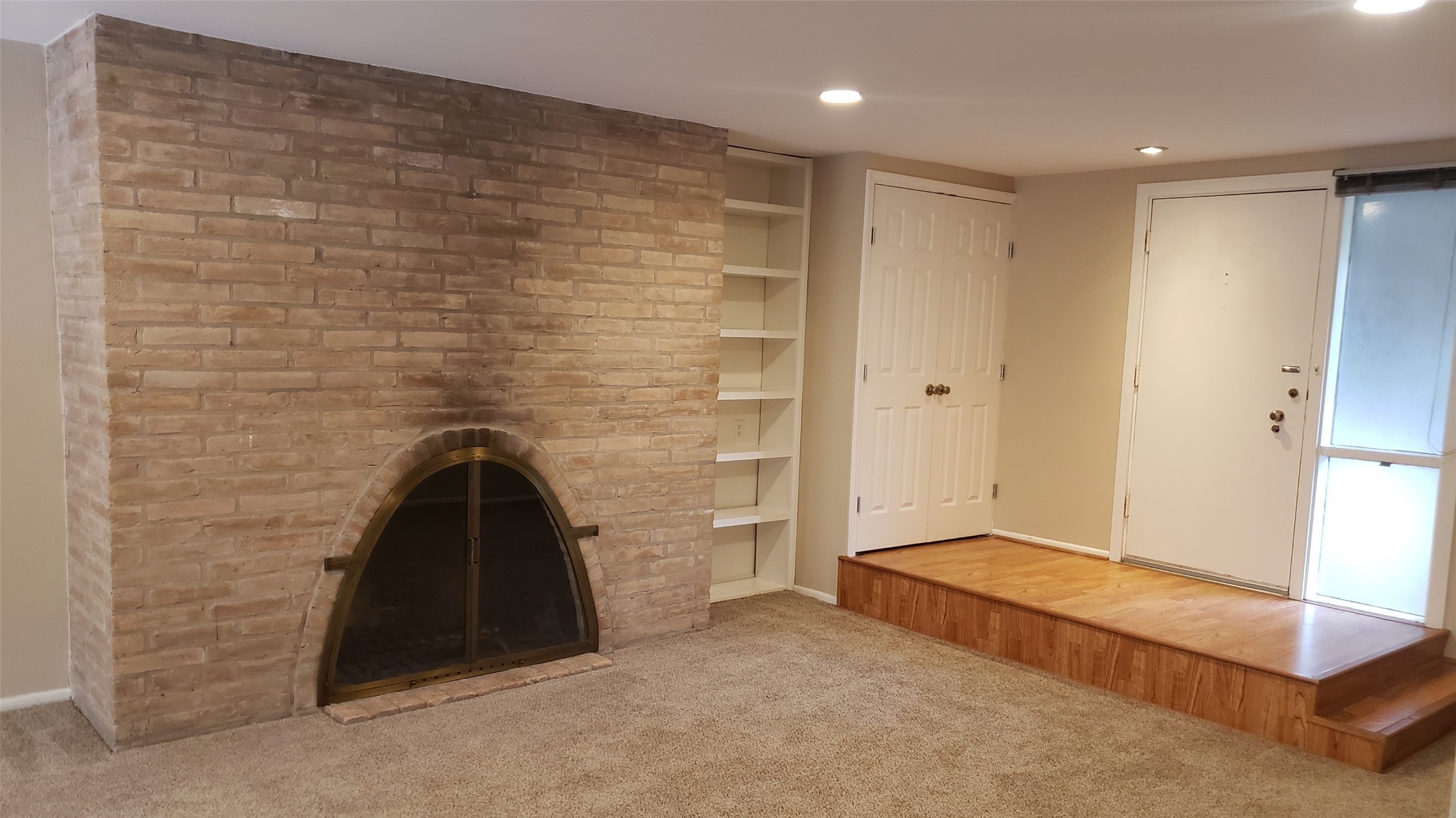 Fireplace in living area. Elevated entry with built in bookshelves & storage closet.