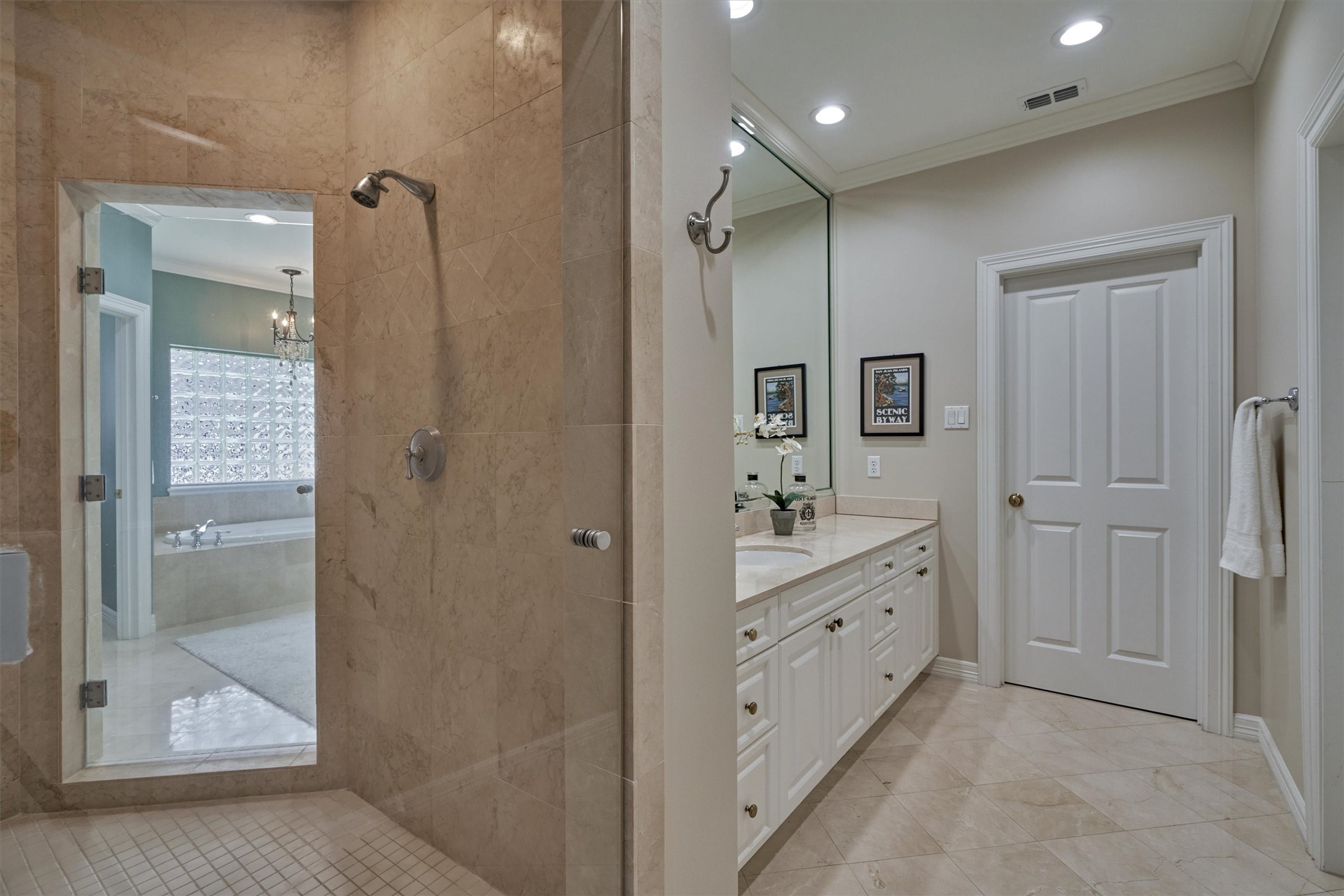 Primary spa-like bath featuring two separate private spaces, both w/ access to dual-entry shower.