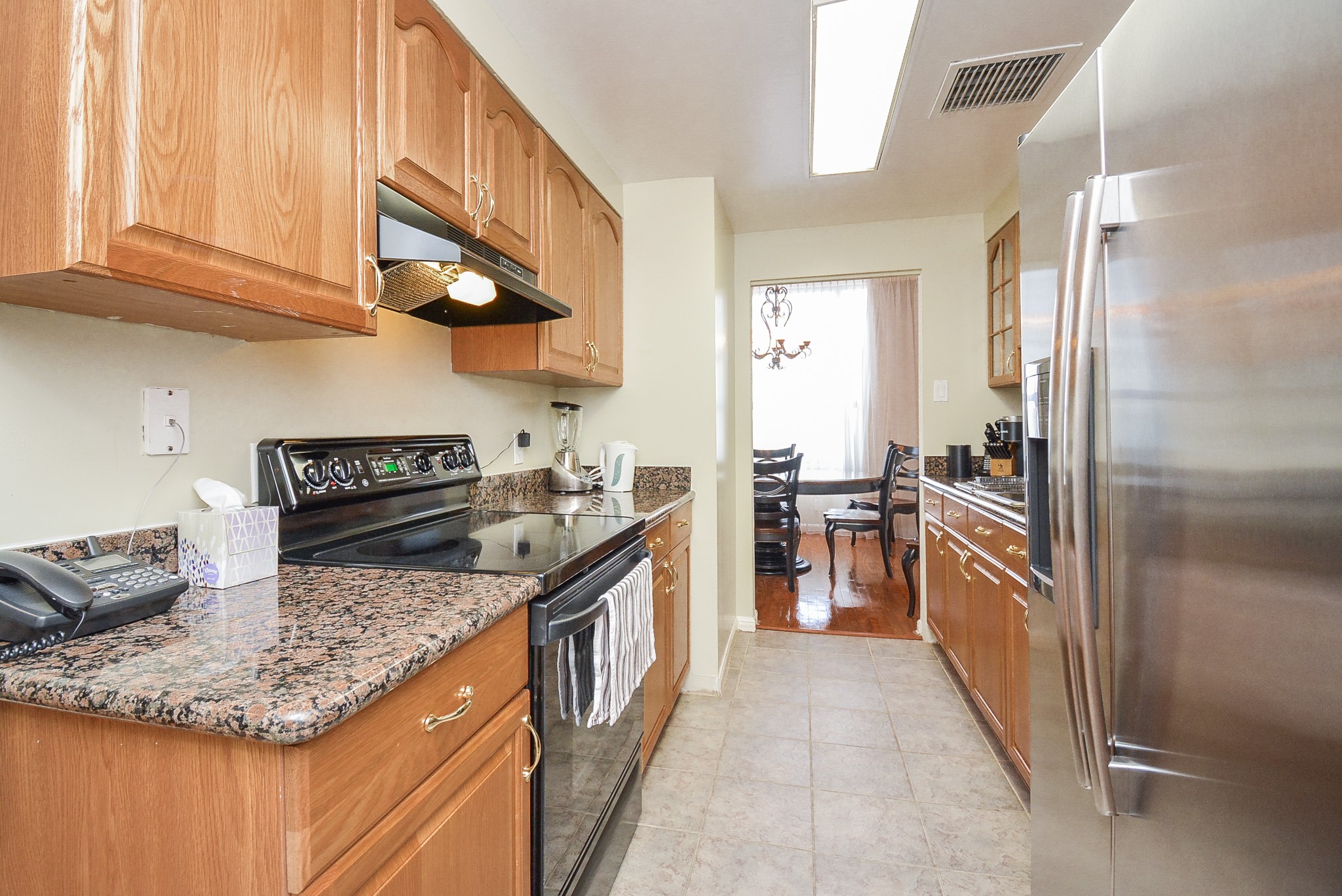 Kitchen with granite countertops and tile floors.