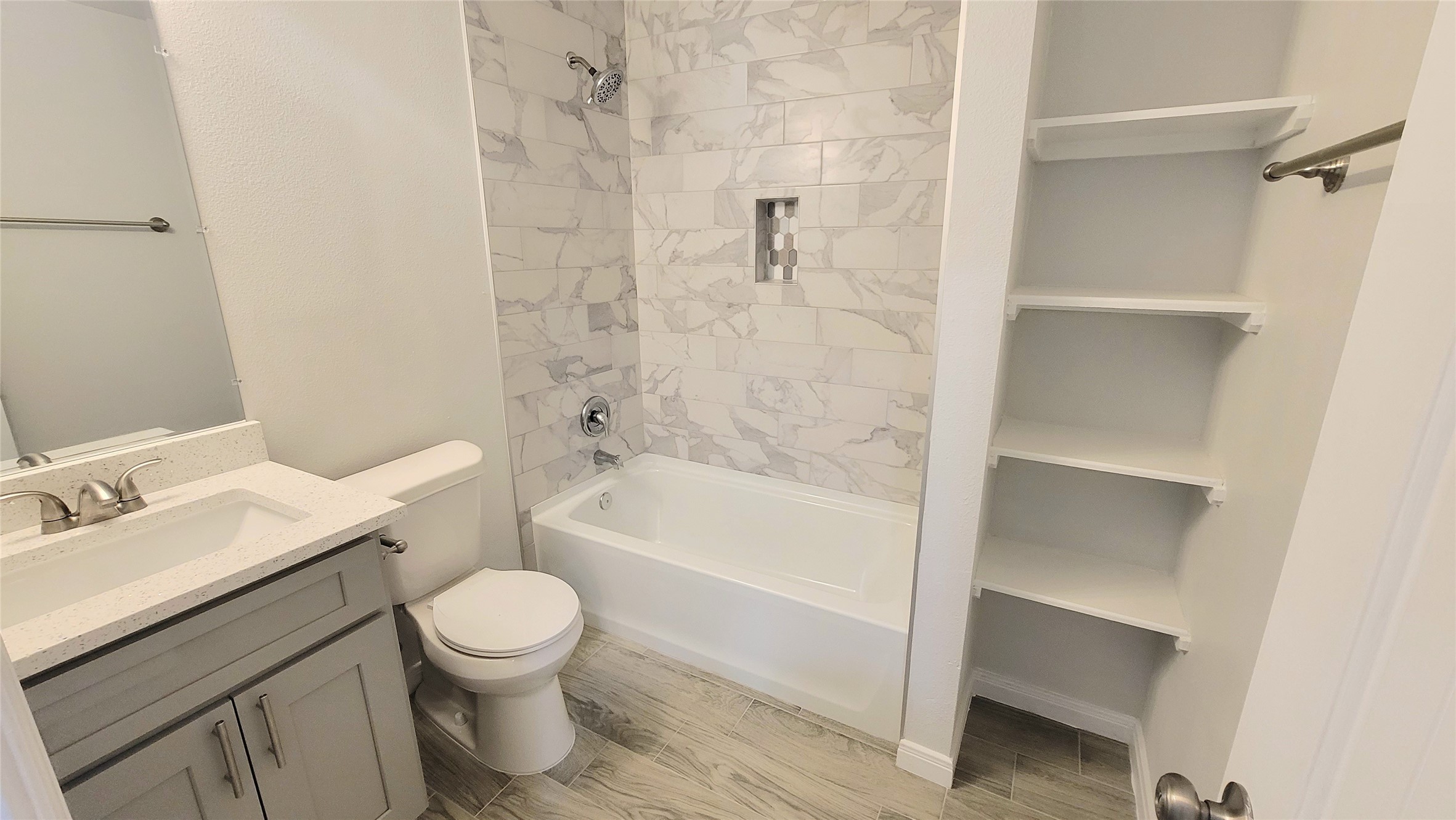 Spacious full bathroom with shelves for towels!