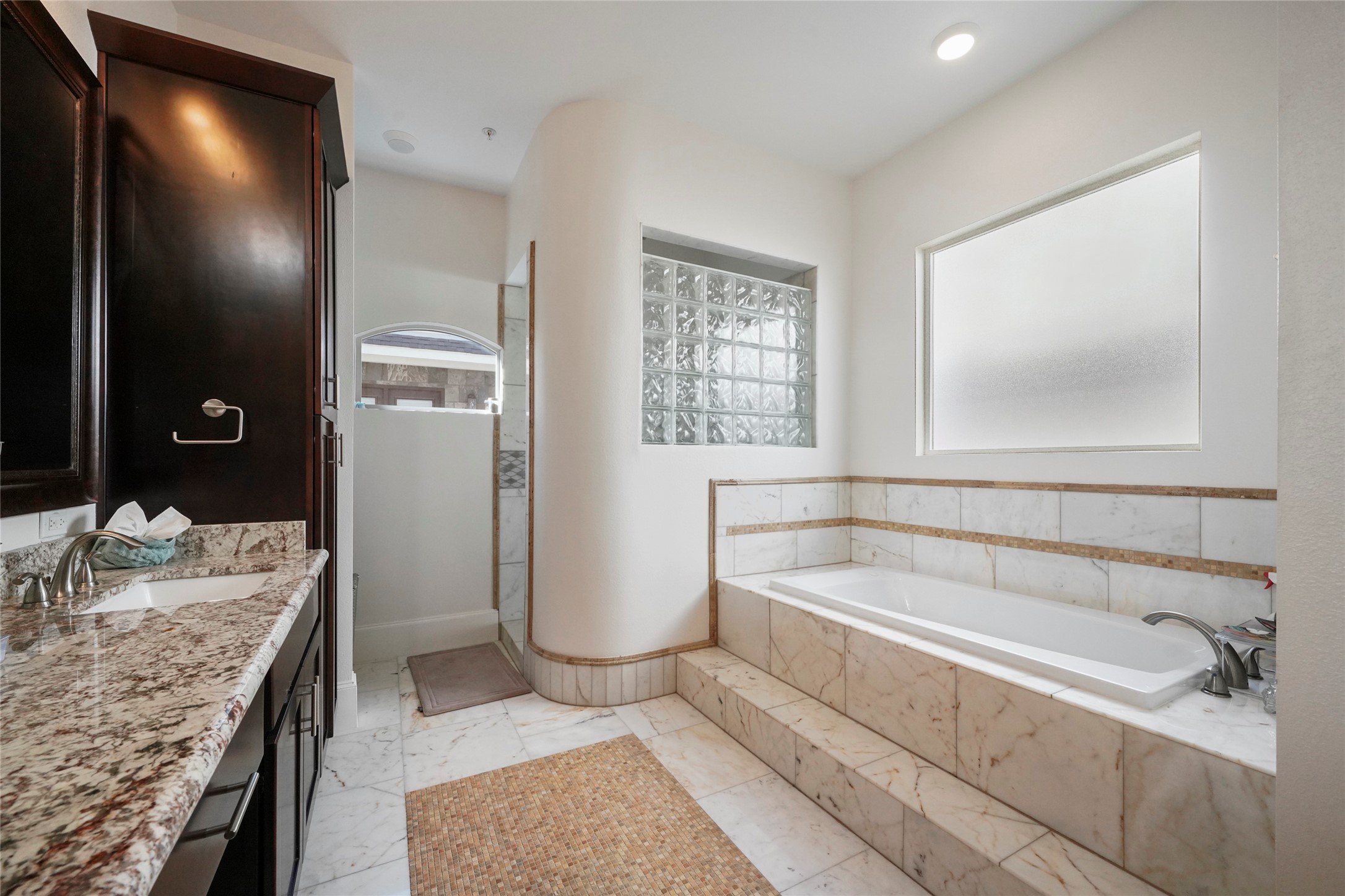 Primary, en-suite bathroom with separate soaking tub and large walk-in closet.