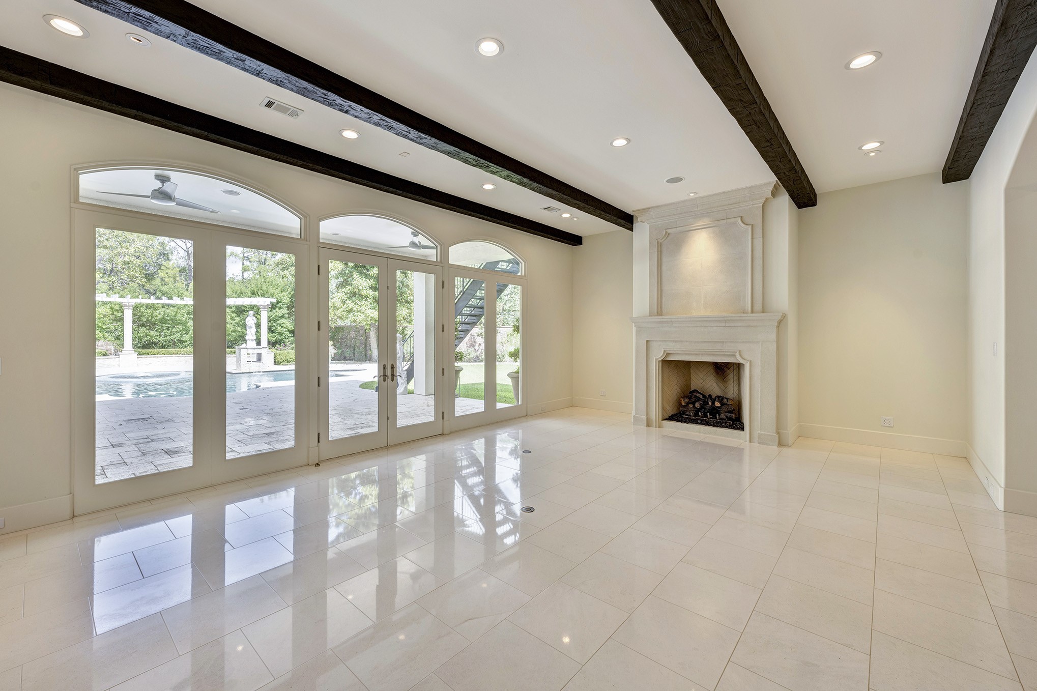 Formal living with cast stone fireplace and french doors to loggia.