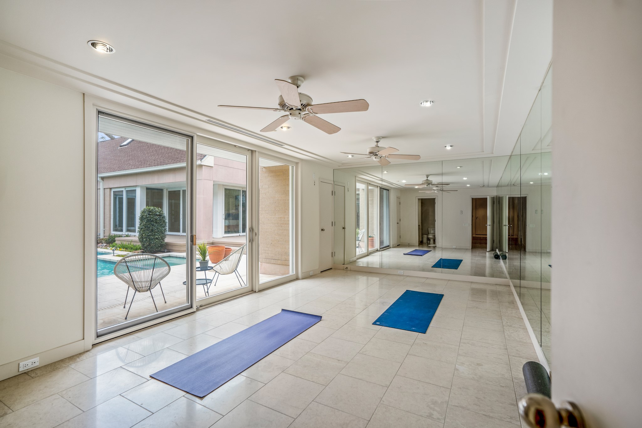 Another bedroom currently being used as a workout space that is overlooking the pool. Wall-to-wall mirrors and a closet in this room as well.