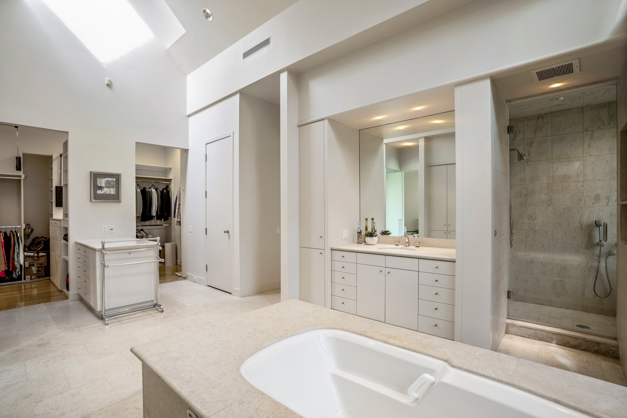 Reverse view of the primary bath retreat featuring two walk-in closets. Stand-up shower on the right. Closed door is the water closet. Inside this room to your left is a zen space. Scroll to see picture.