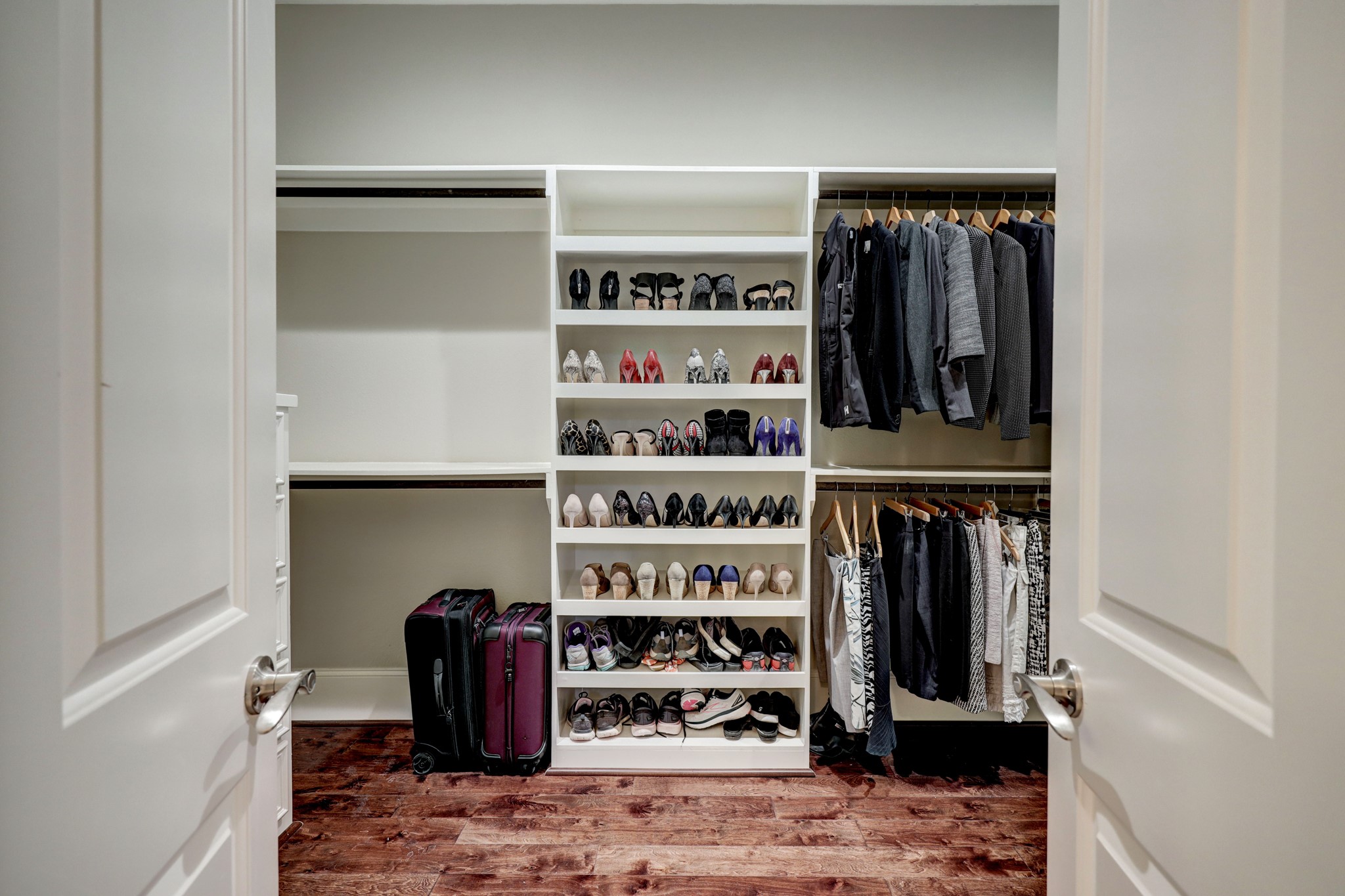Look at this fabulous walk-in closet with built-in shelves and drawers and tons of hanging space and storage.