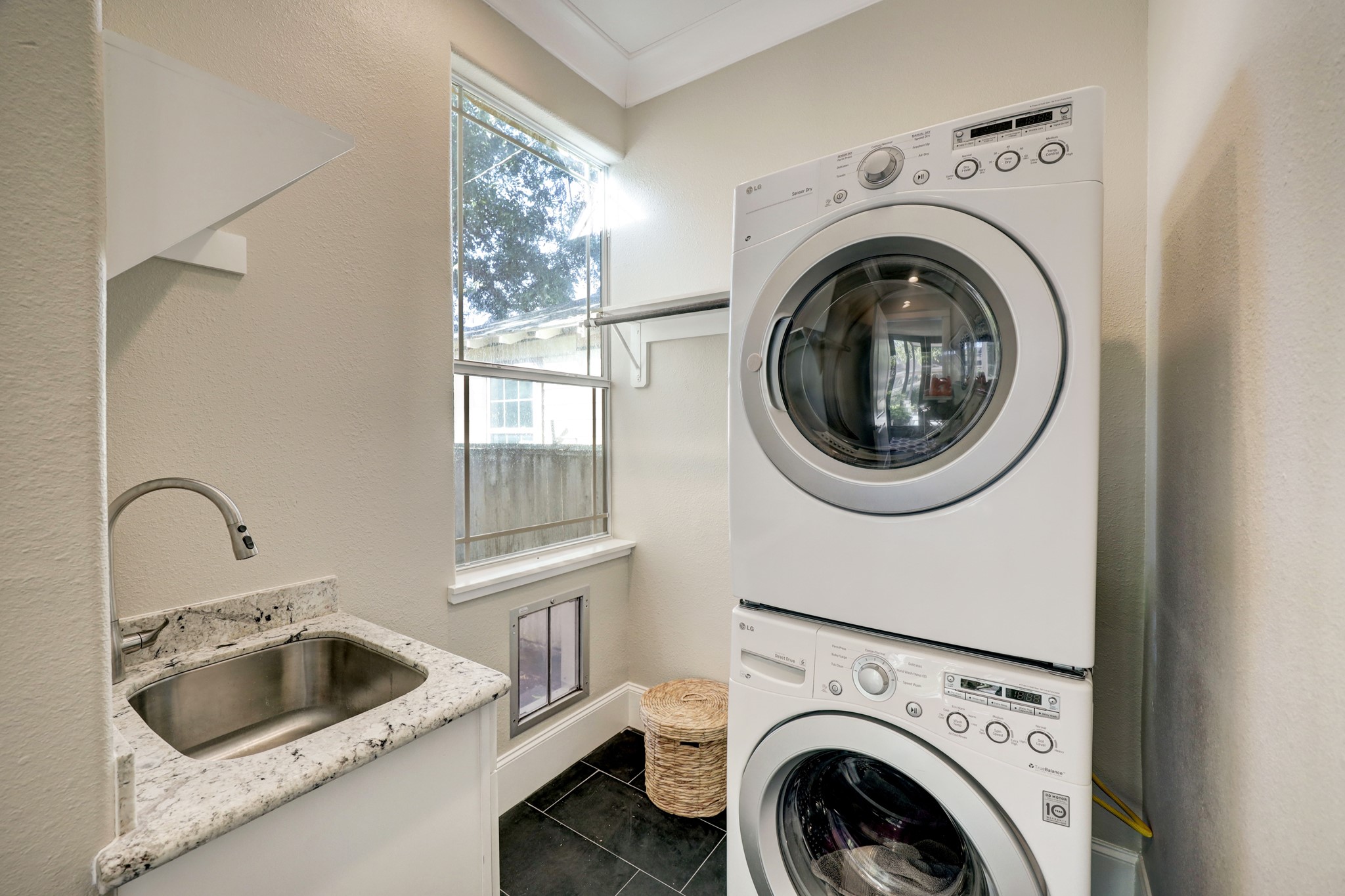 The oversized laundry room includes a sink, electric and gas hookups for dryer, and a dog door.
