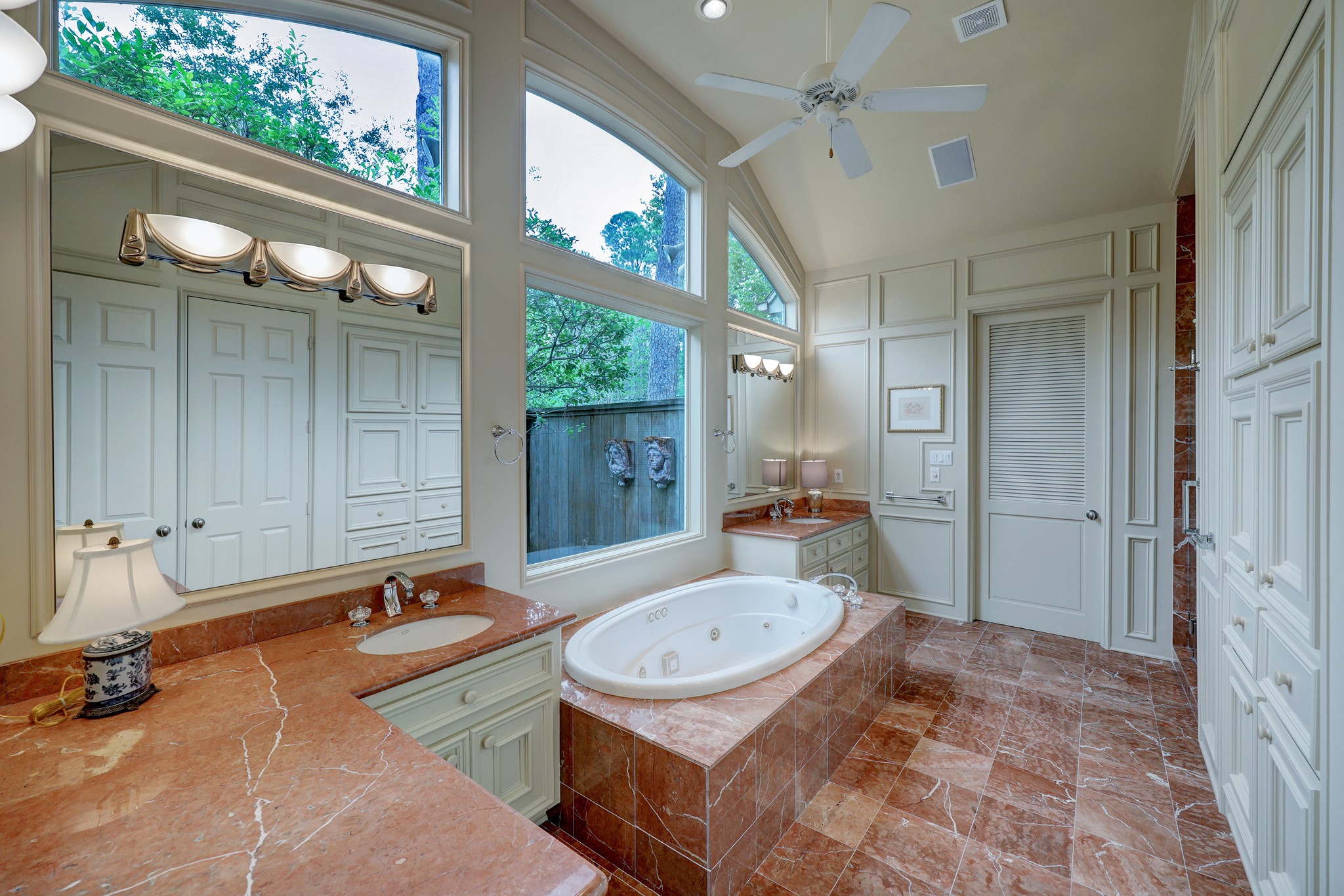 Primary bathroom with yours-and-mine vanities.  The large closet is at the end behind louvered door.
