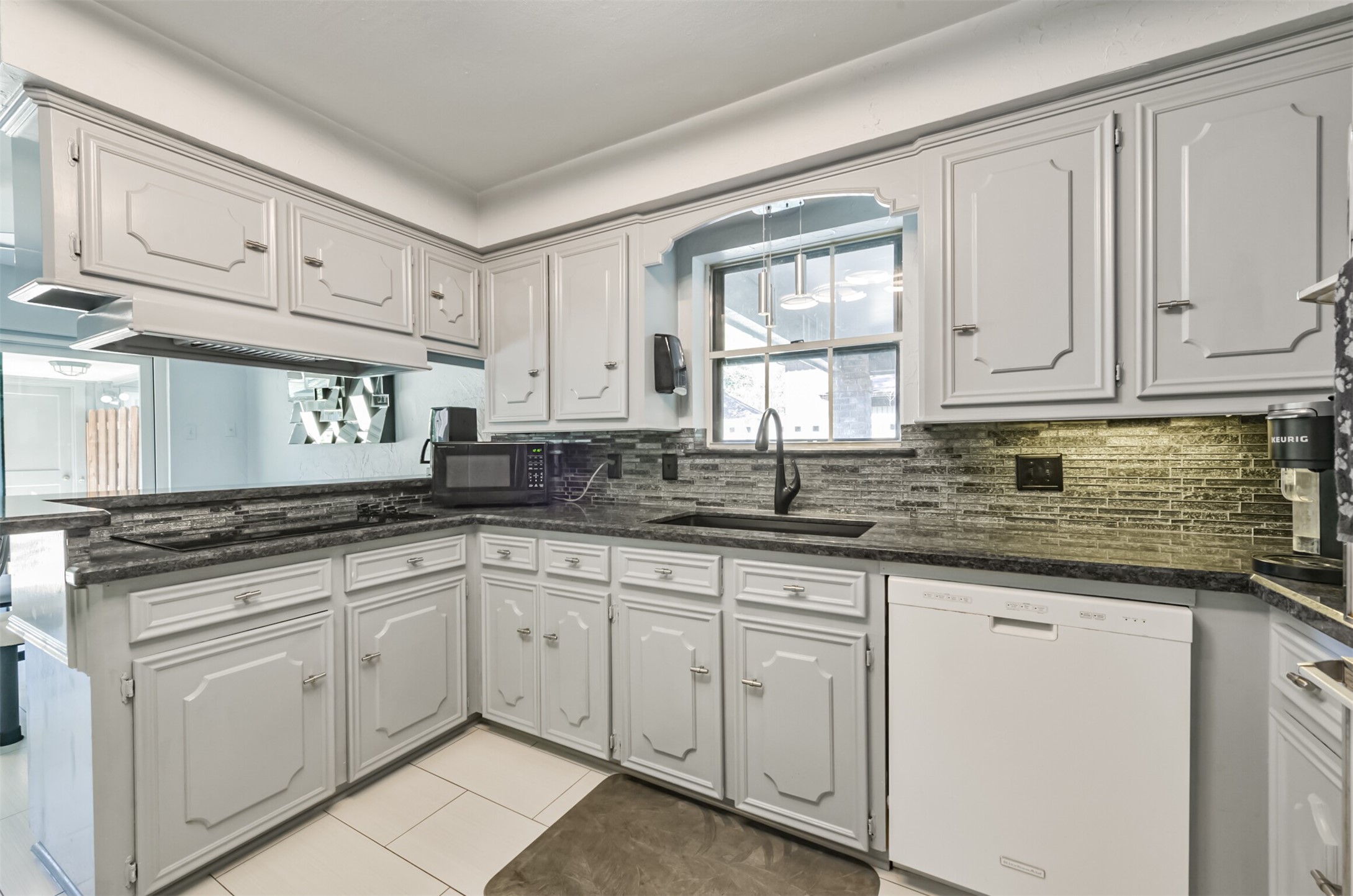 Beautiful granite, nice back splash and painted cabinets make for a dramatic kitchen.