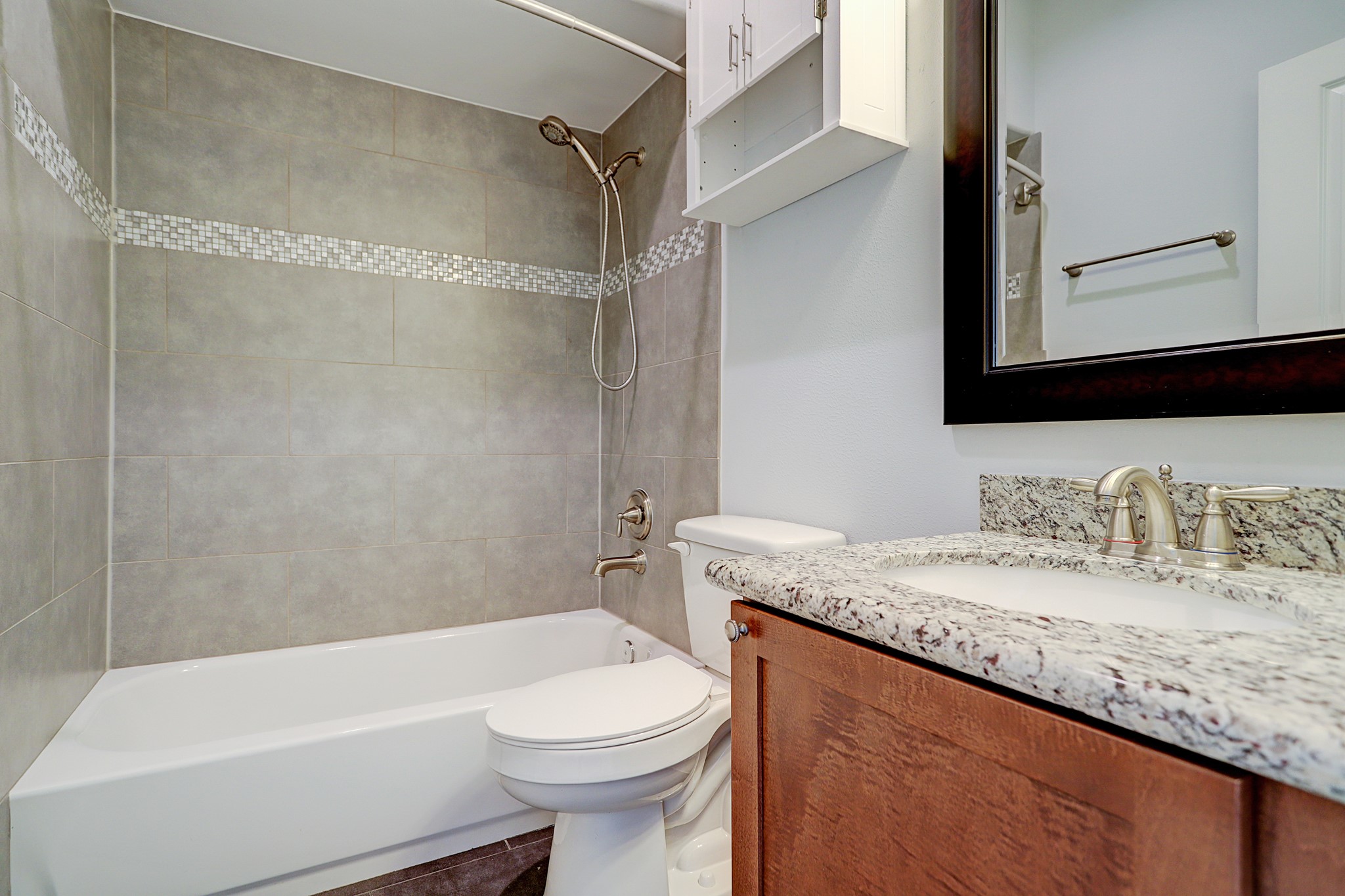 The first floor bath has granite counters with chrome plumbing fixtures.