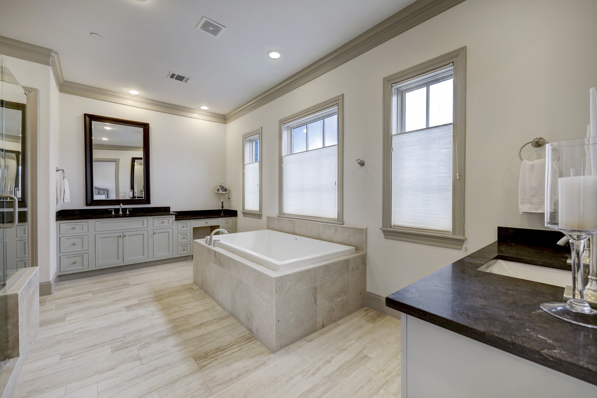 Spa like primary bath with separate vanities, large soaking tub and glass shower. Primary suite offers 2 closets.