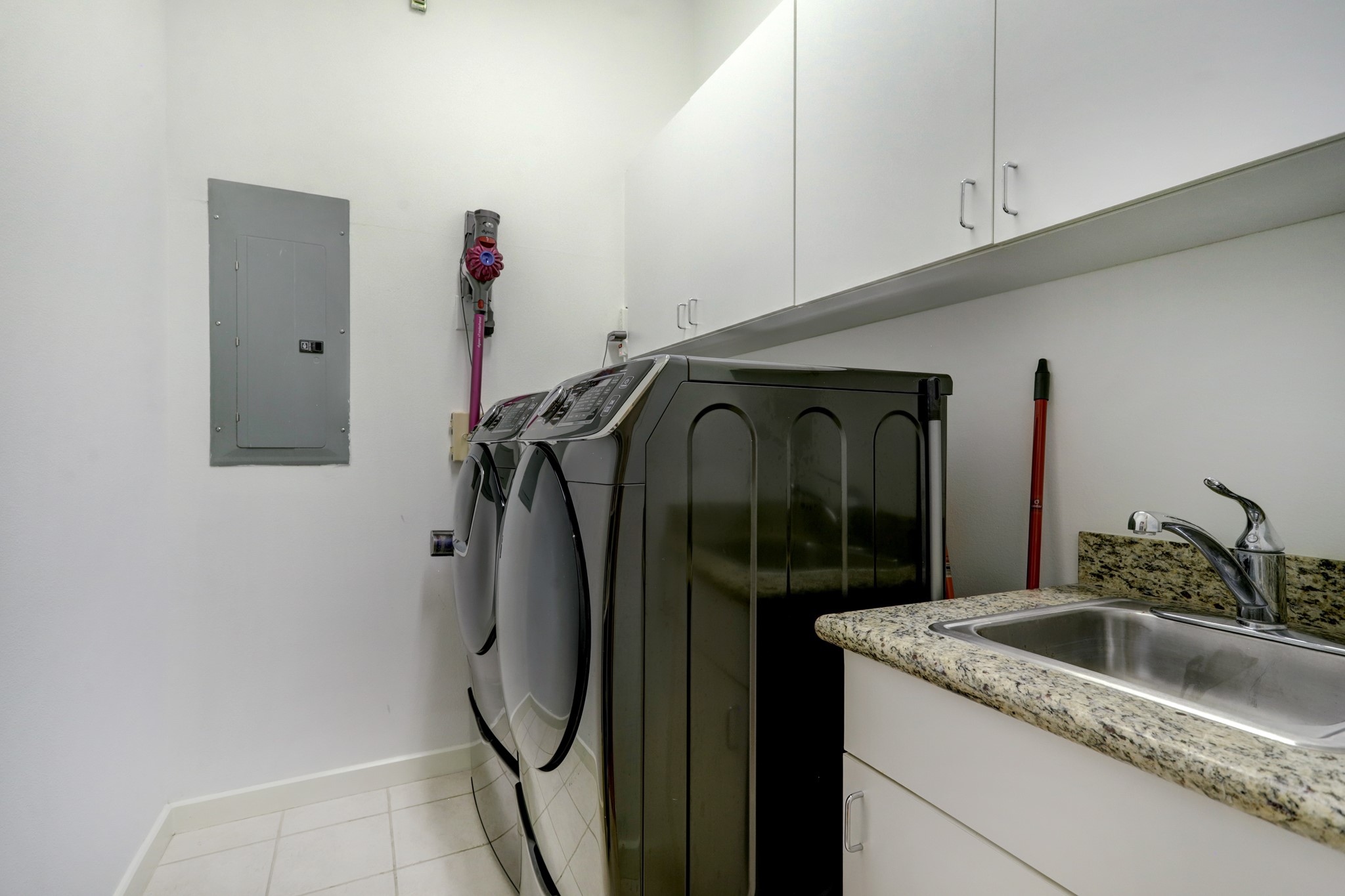Laundry room in the unit with sink and extra storage.