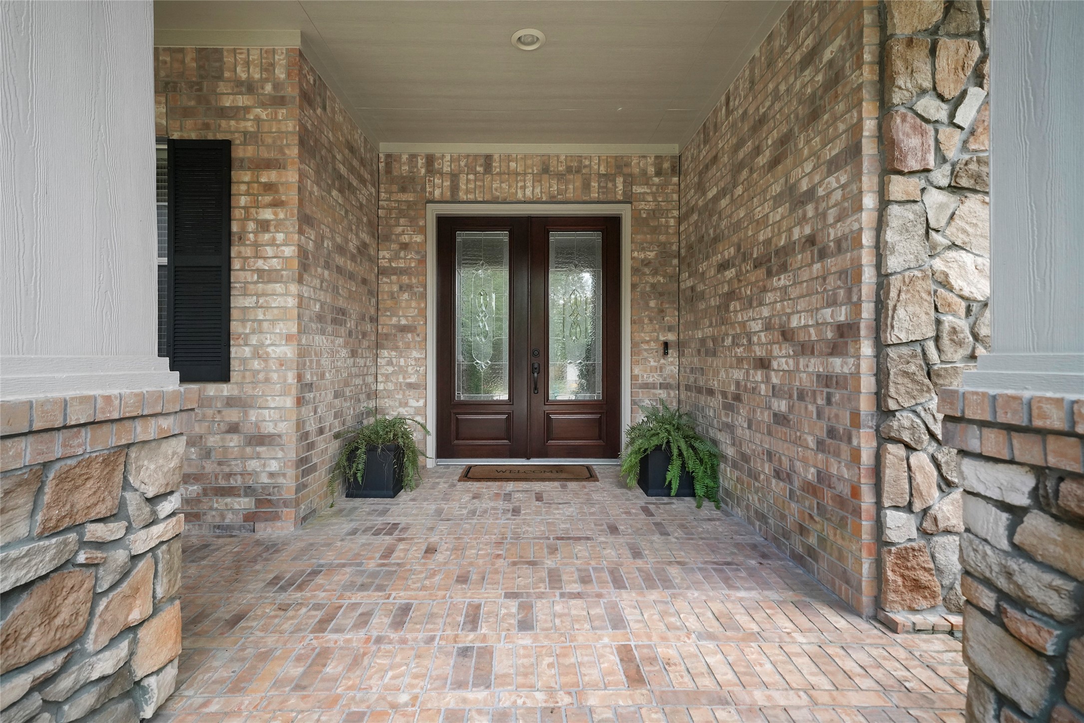 Guests are welcomed by a deep, covered, French door entry with inlaid leaded glass.