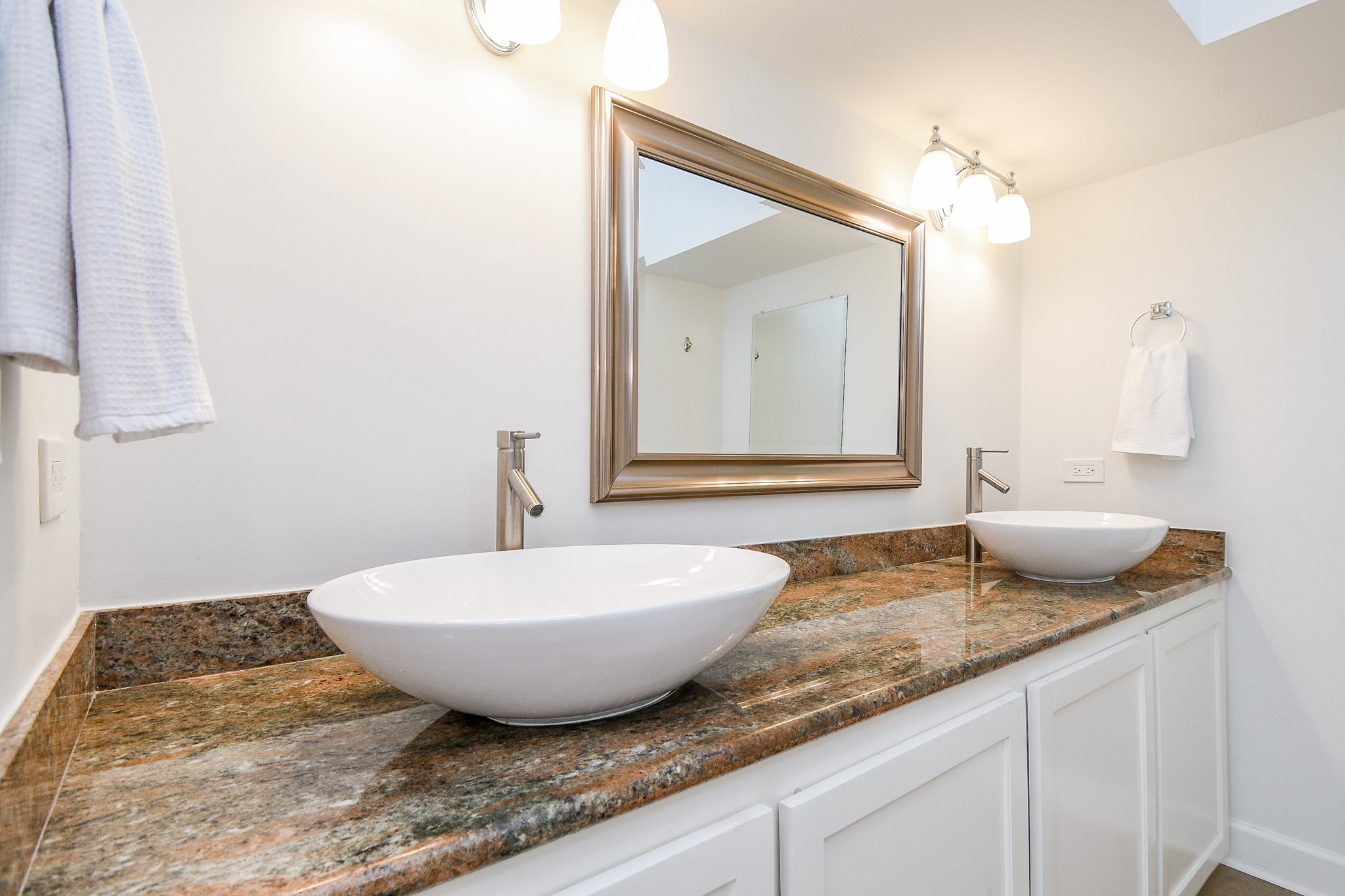 The ensuite bathroom features elegant granite counters