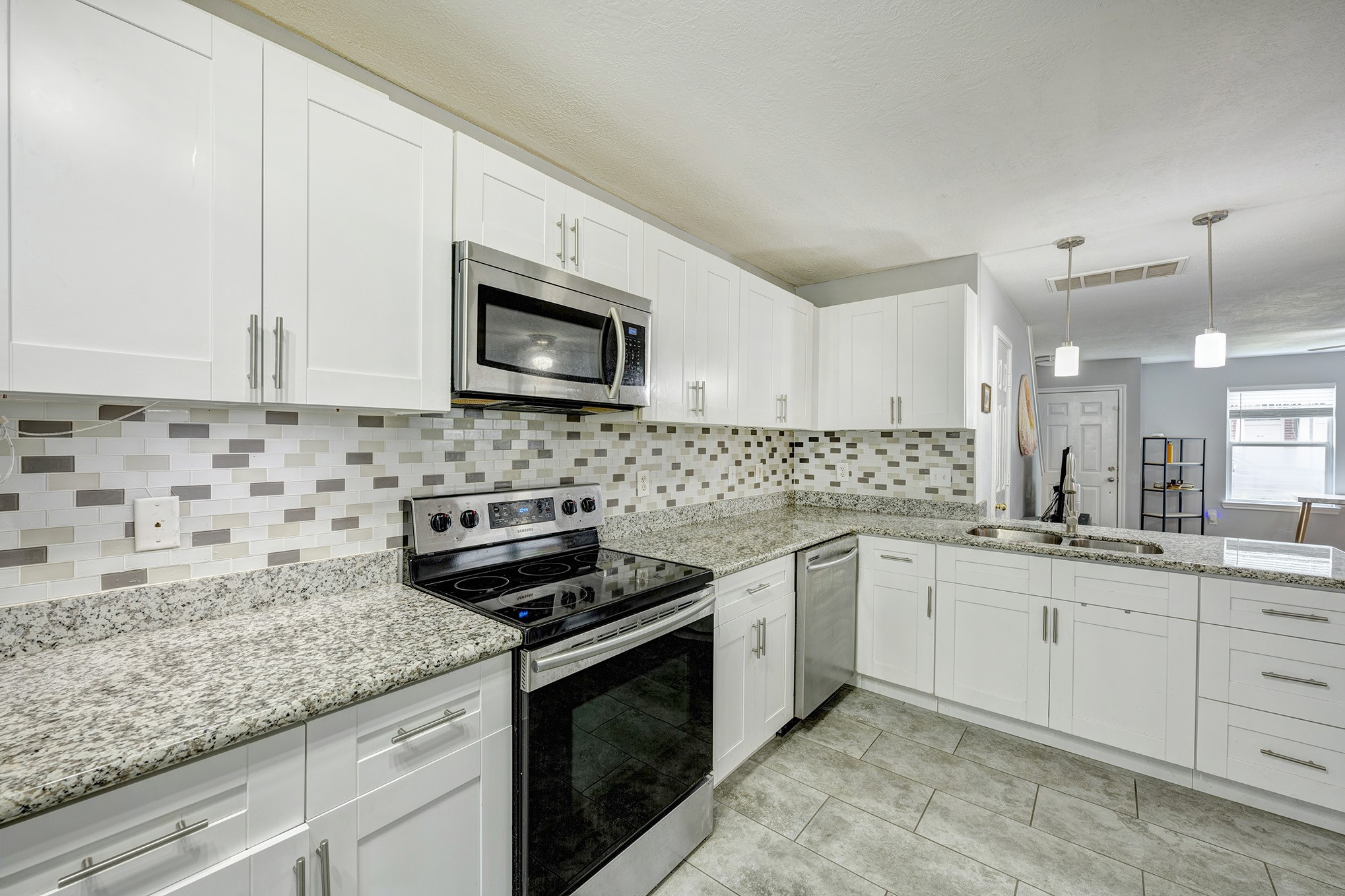 Granite counters and designer backsplash. Microwave above oven/cooktop. Stainless appliances.