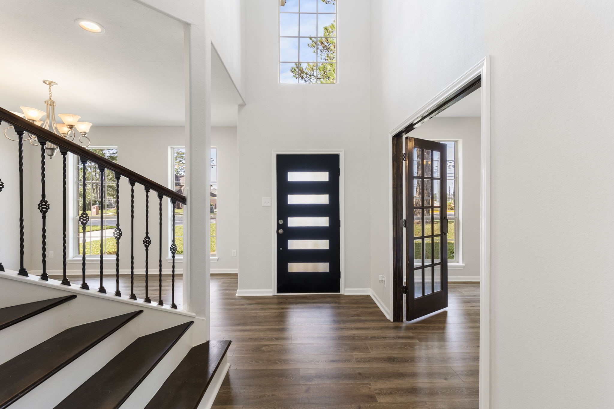 Another view of the light and bright foyer. You will find new laminate flooring, six panel doors and fresh paint throughout the home. Bonus storage in closet under the stairs!