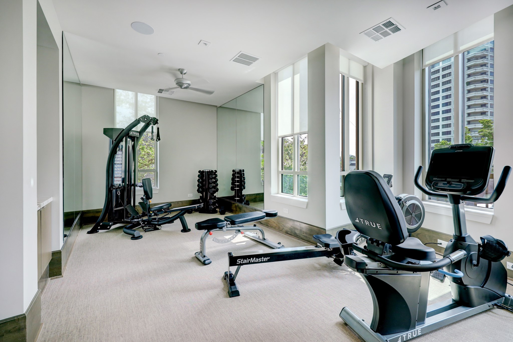 The third floor EXERCISE ROOM with its multiple machines for the active resident to work out while viewing the River Oaks area from the facility's expansive windows.