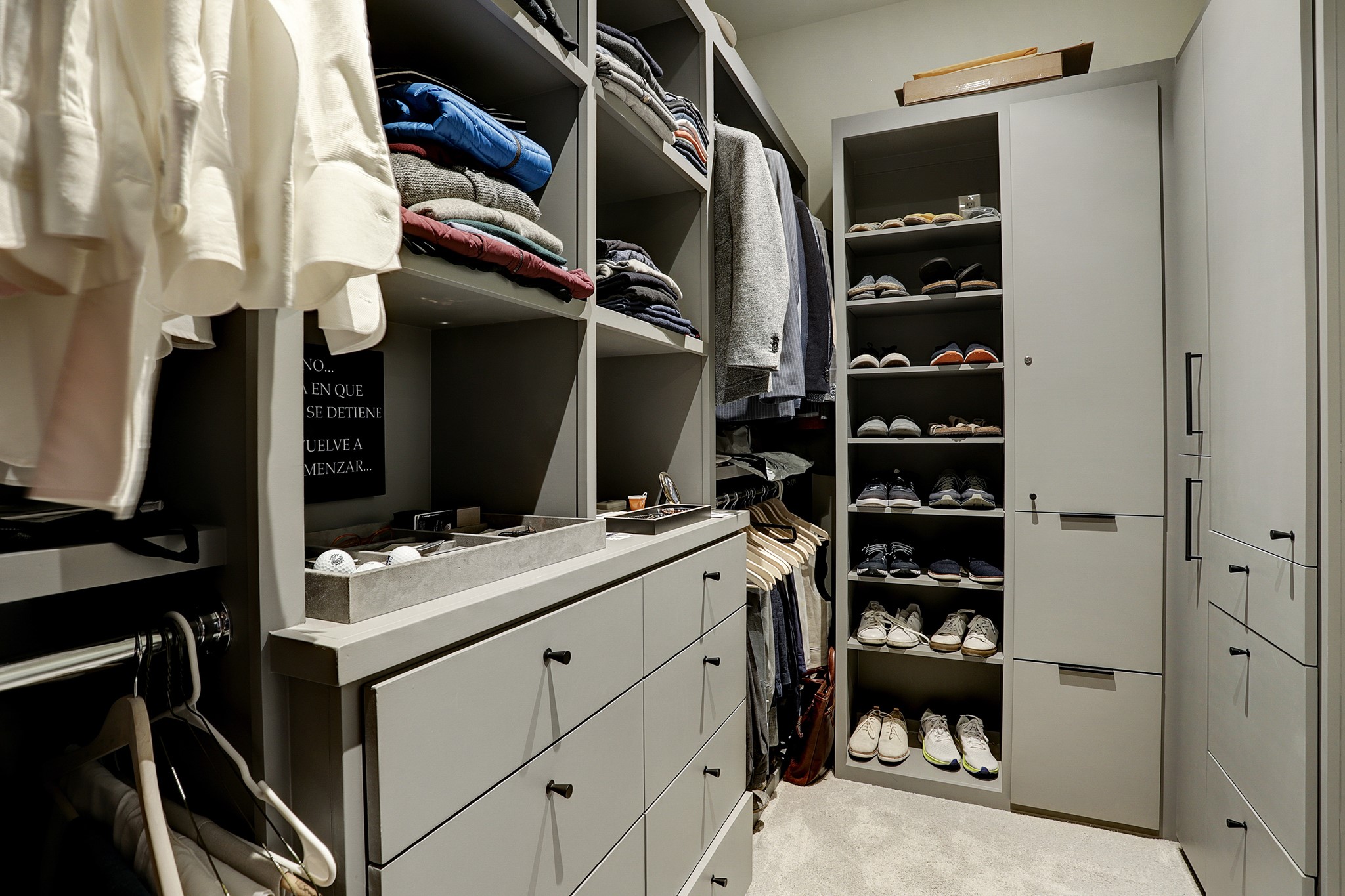 The CUSTOMIZED WALK-IN CLOSET also has additional storage cabinets and plush carpeting.