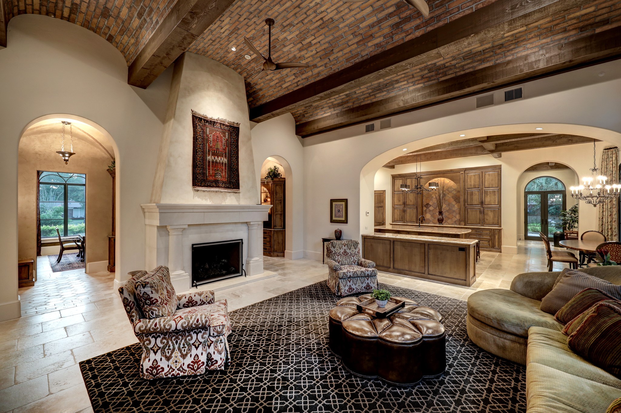 View from family room facing the stone fireplace and arched entryways to the wet bar