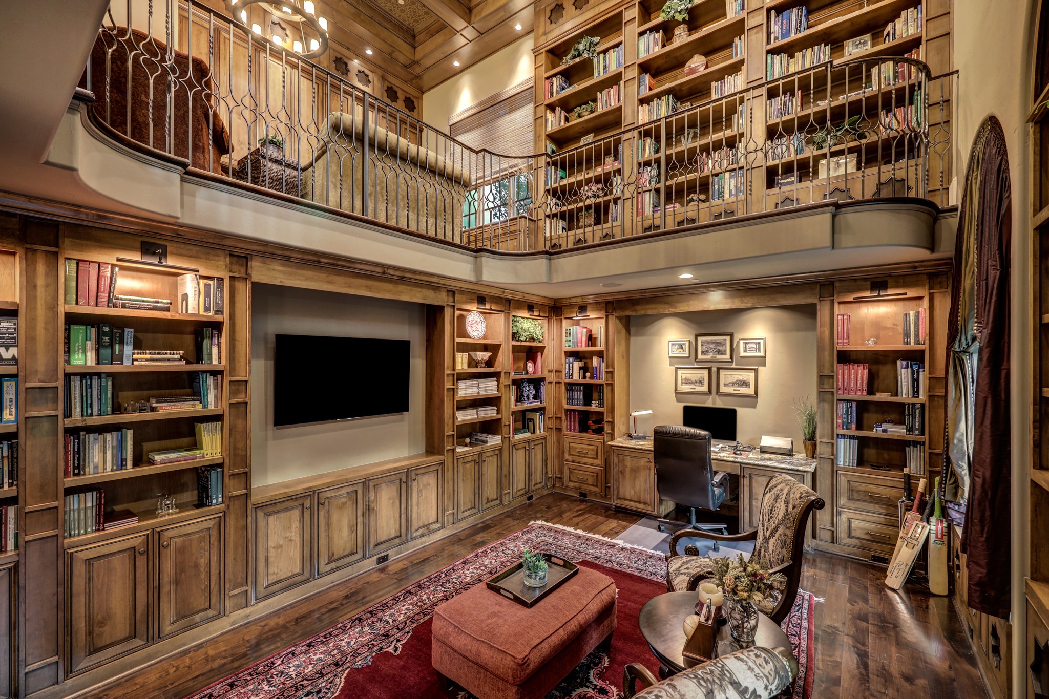 Surrounded by custom wooden book shelving, built-ins and cabinets