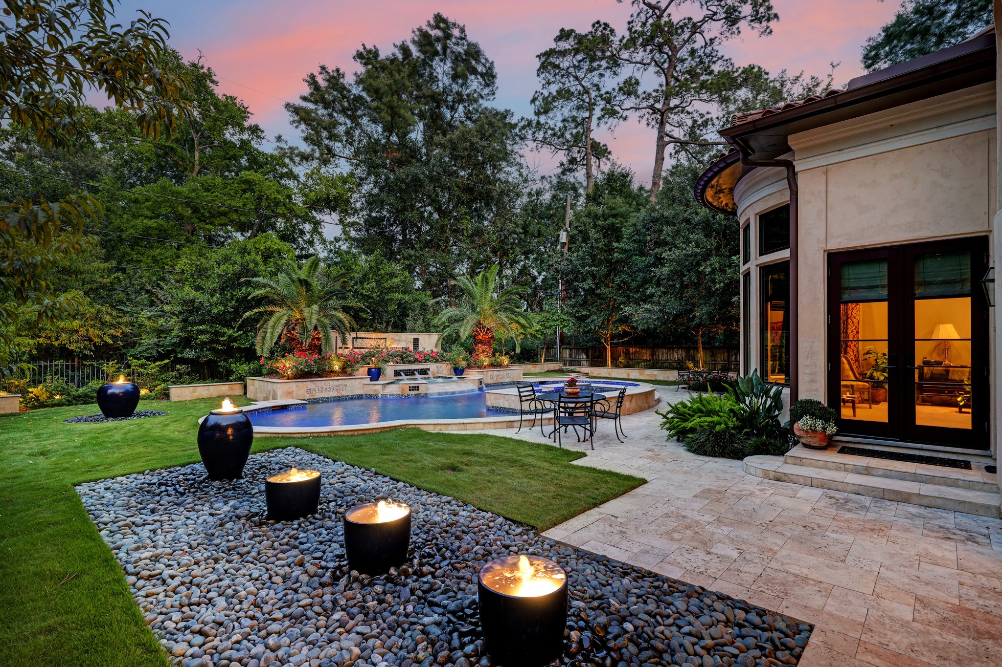 An oasis-like hideaway surrounded by tall privacy hedges and extensive manicured landscaping