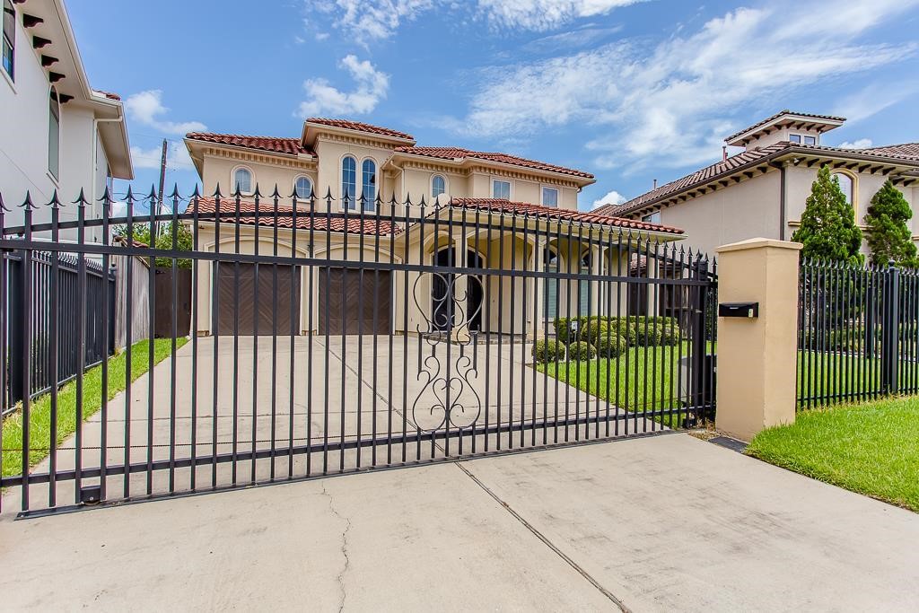 Behind iron gates, massive columns and graceful arches under a tile roof, make this custom home stand-out in a well-located Galleria area alcove.