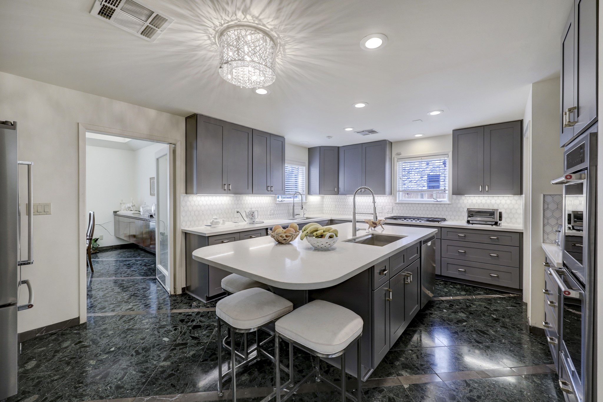 The kitchen was previously renovated with new soft close cabinetry, backsplash tile, stainless steel appliances, counter lighting and quartz countertops.