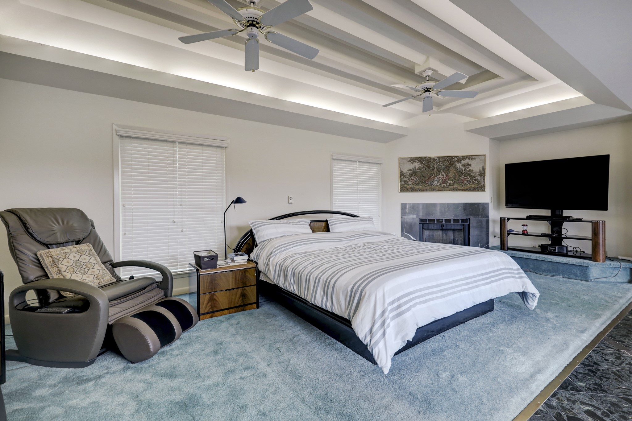 The primary suite is comprised of daul closets, a wall of storage, intricate ceilings with incandesent lighting, corner fireplace, dark room, craft room, study overlooking the pool.