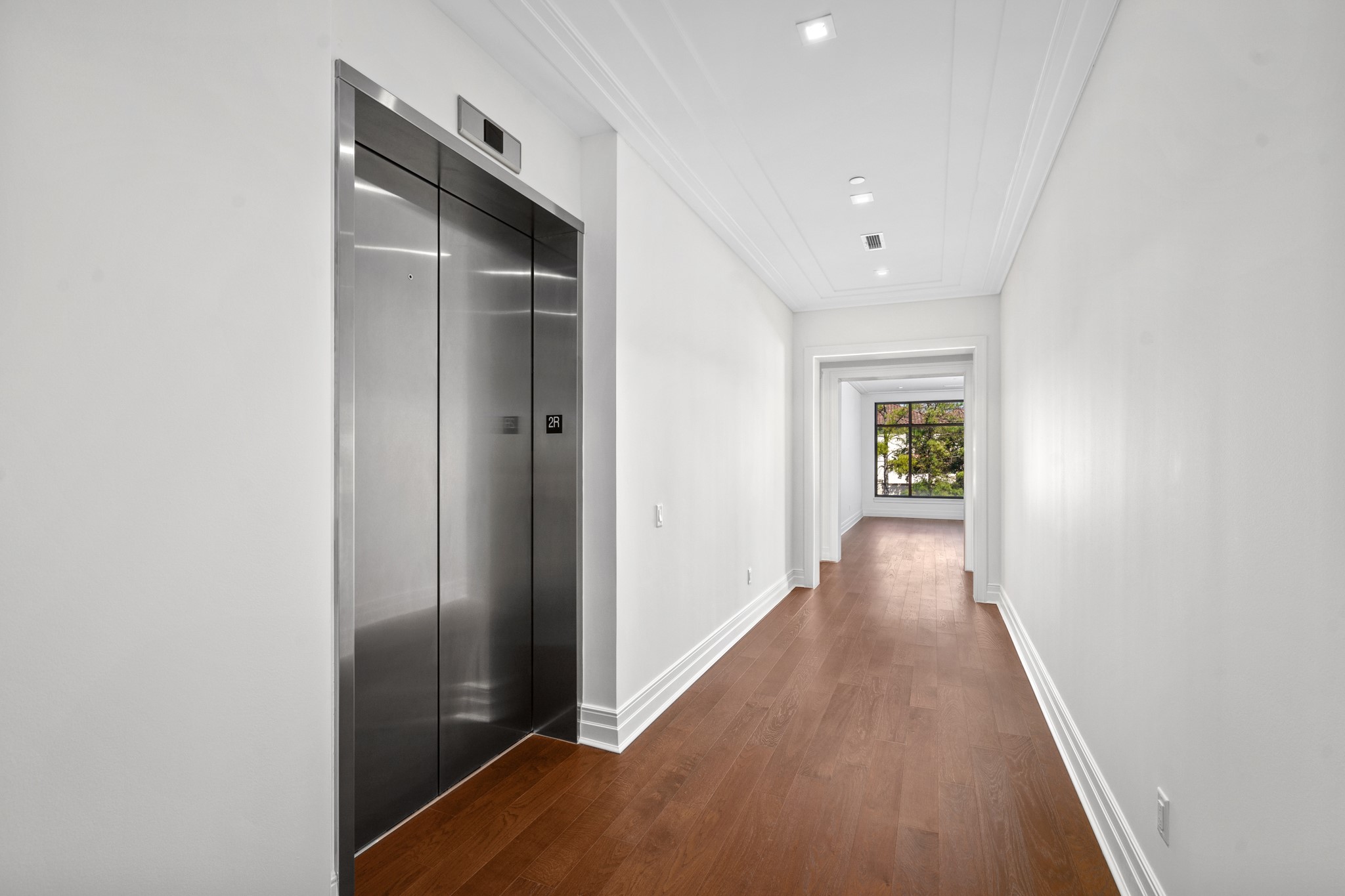 The elevator-facing entrance opens into a broad reception hallway perfect for displaying art.