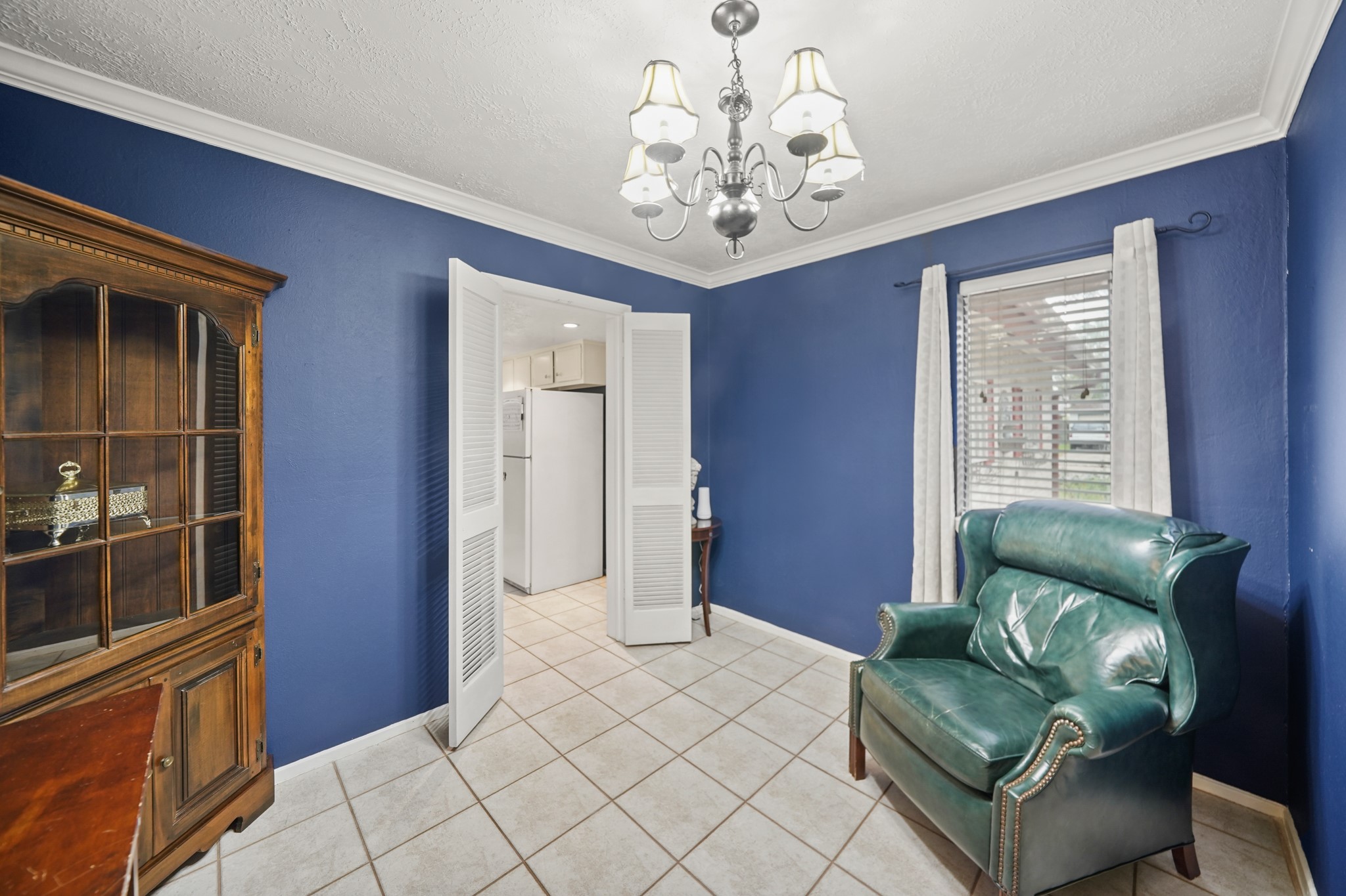 You'll appreciate the flexibility in this great floorplan with a spacious breakfast area or den just off of the foyer. This space offers tile floors, decorator paint, crown molding, and a stylish chandelier. By-fold doors lead to the kitchen.