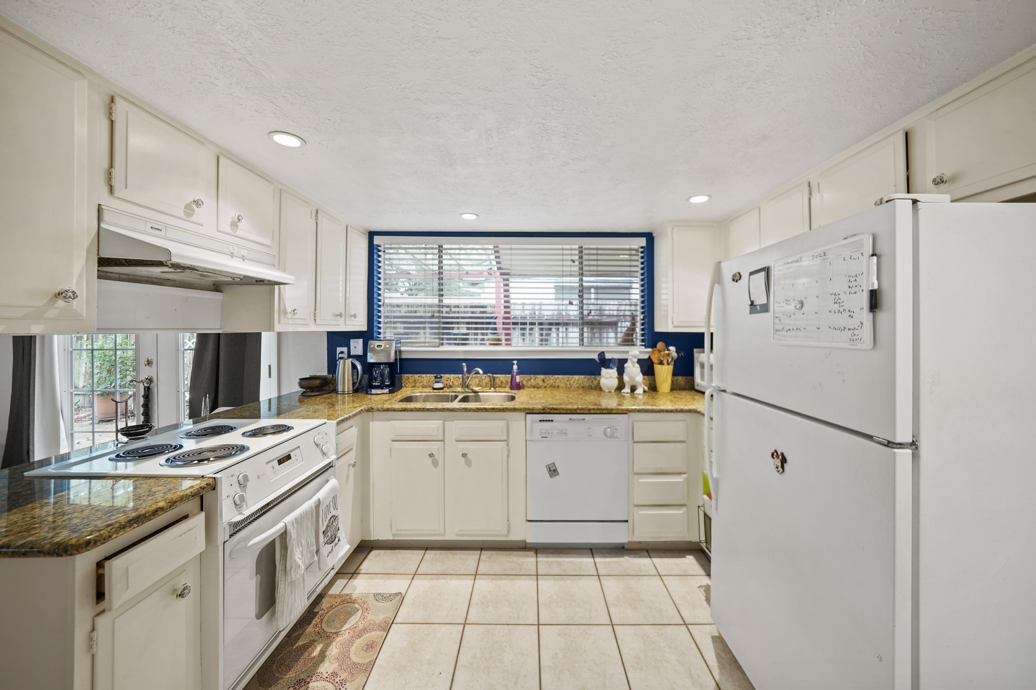 Show off your culinary skills in this immaculate kitchen featuring tile floors, granite countertops, designer paint, and lots of cabinet space.