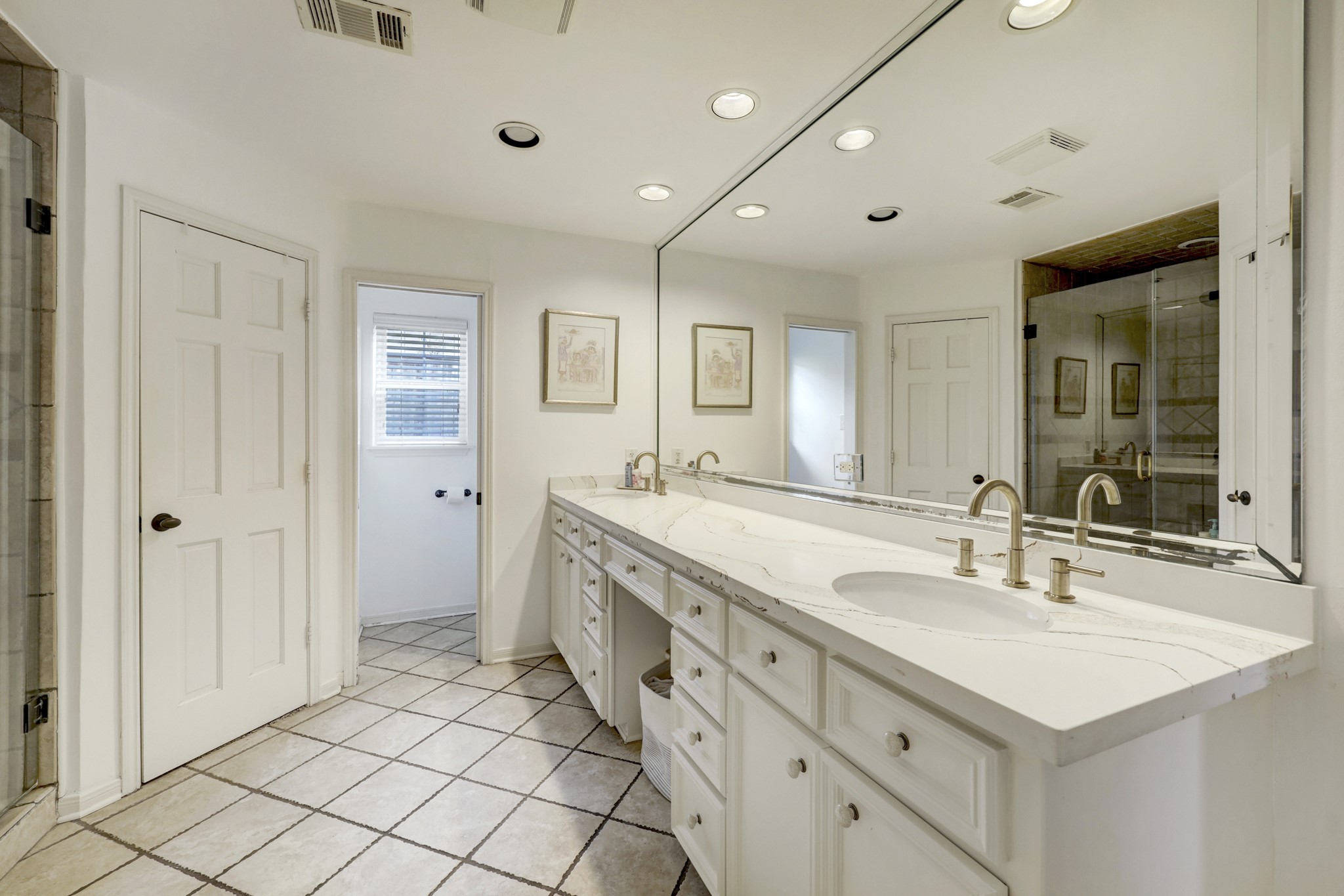 Primary bath offers updated fixtures and Quartz countertops. There are two walk-in closets on either side of the shower.