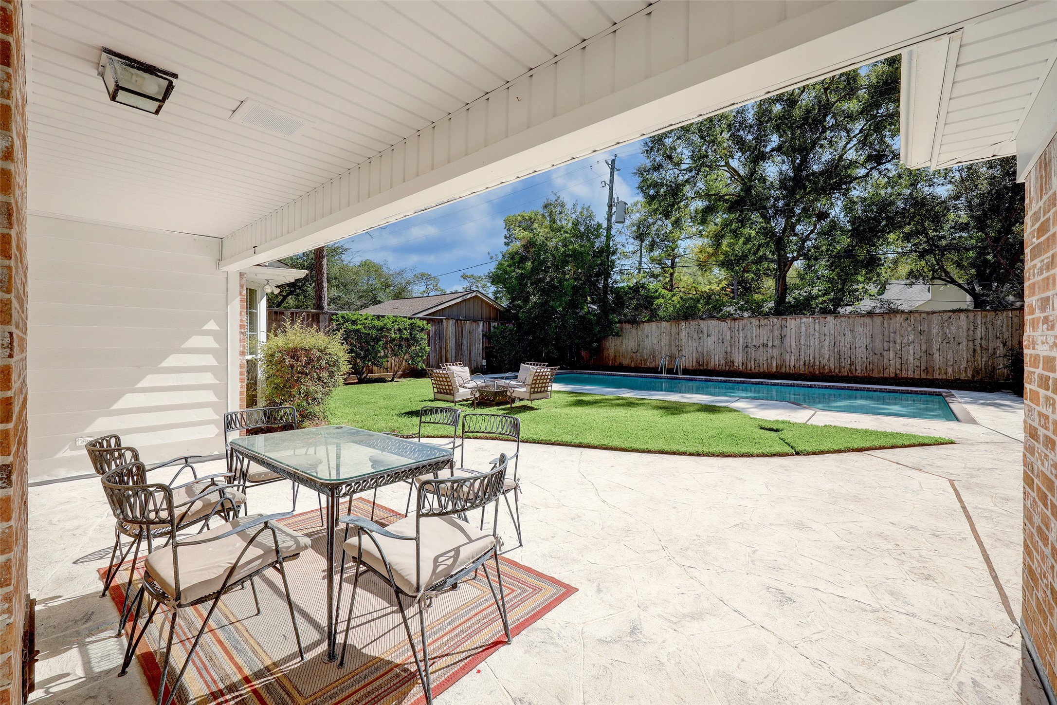 Incredible view of the backyard and pool. Covered sitting area is perfect for an outdoor dining space.