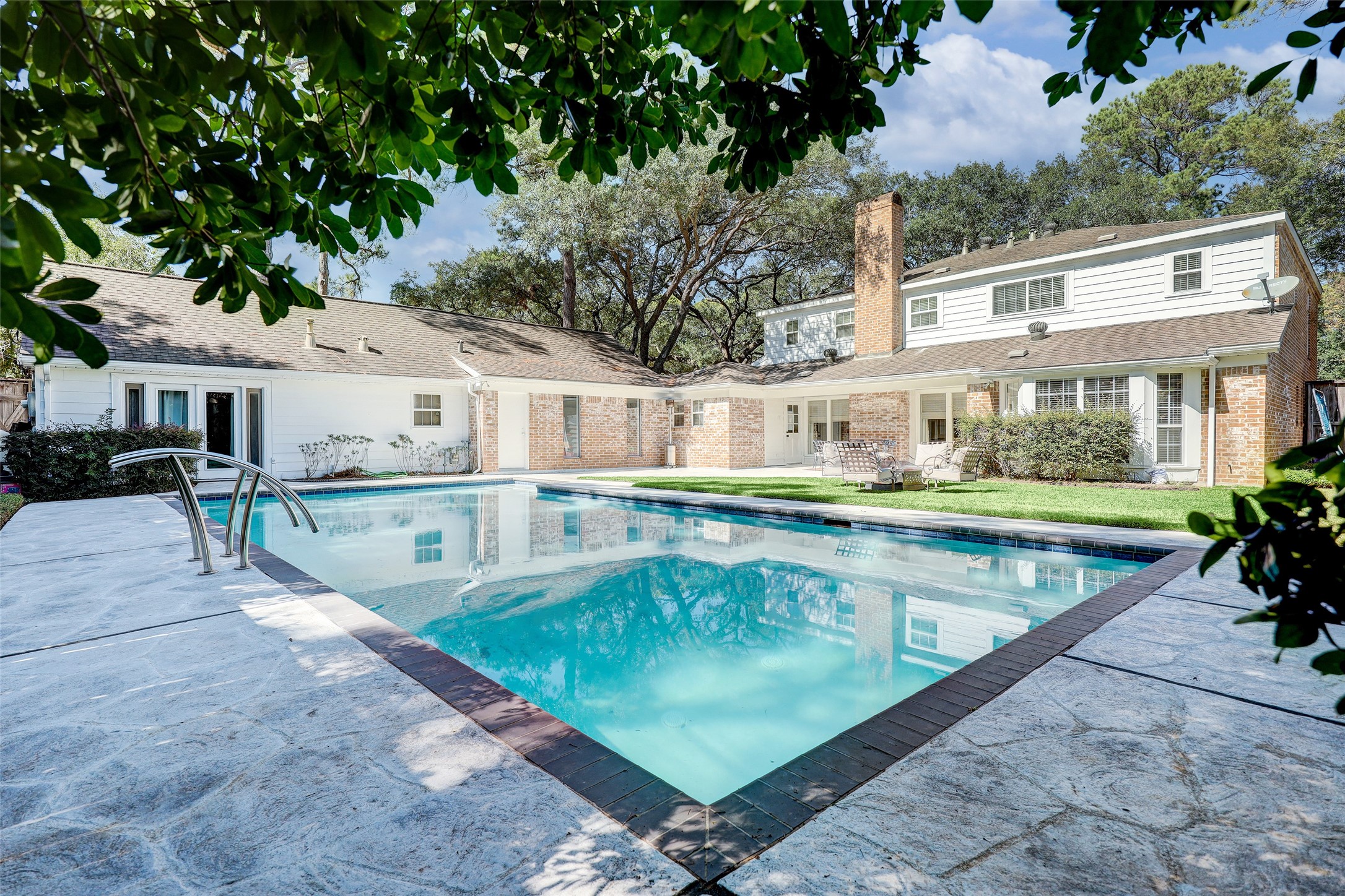 Backyard provides a large pool and no shortage of green space. Access to the finished studio can be seen to the far left.