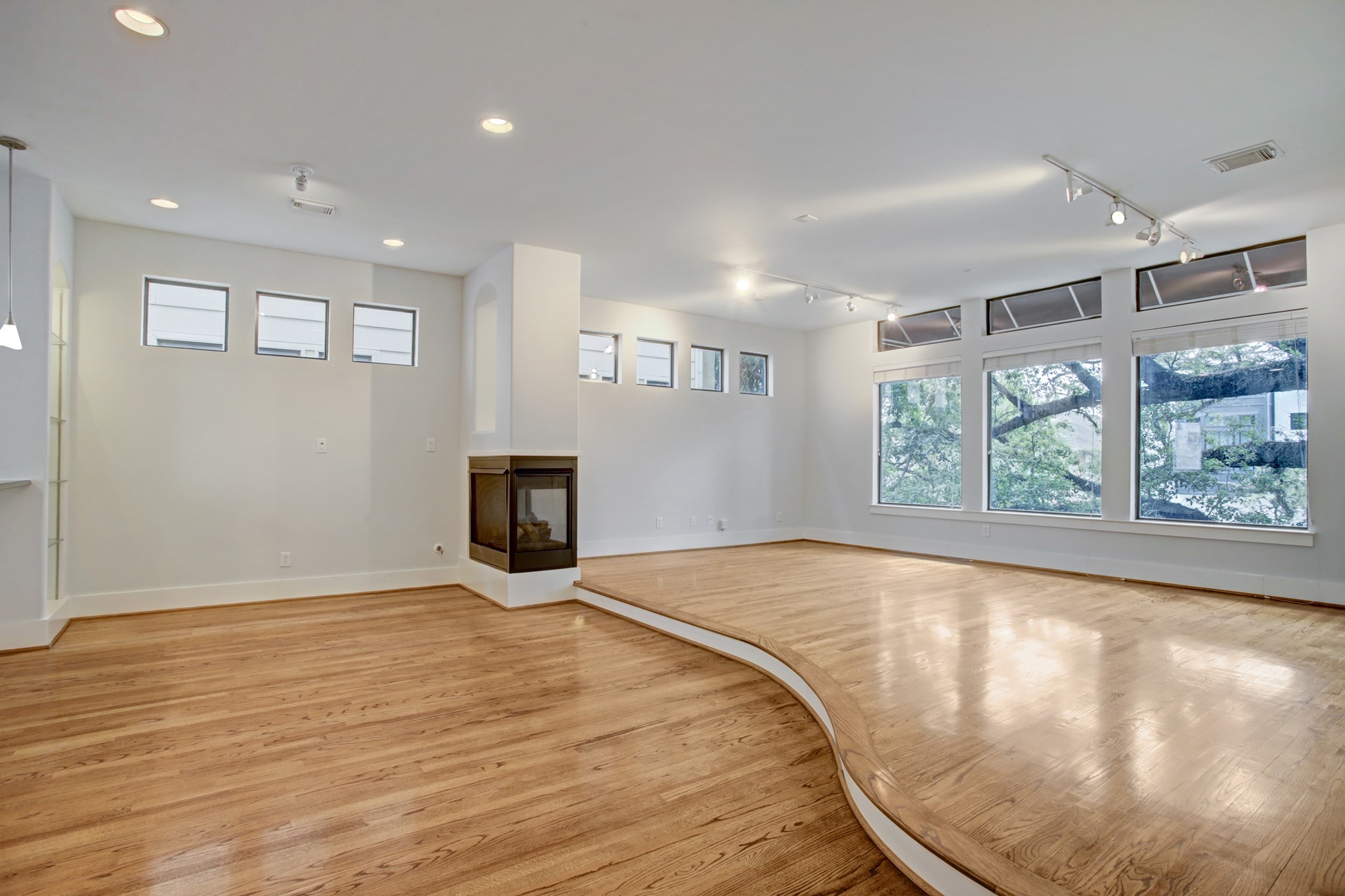 Great view of the living space and 3-sided fireplace lit naturally by the wall of windows. Notice the beautiful Oak tree just outside the wall of windows. 4622 Feagan can be your own private tree house.