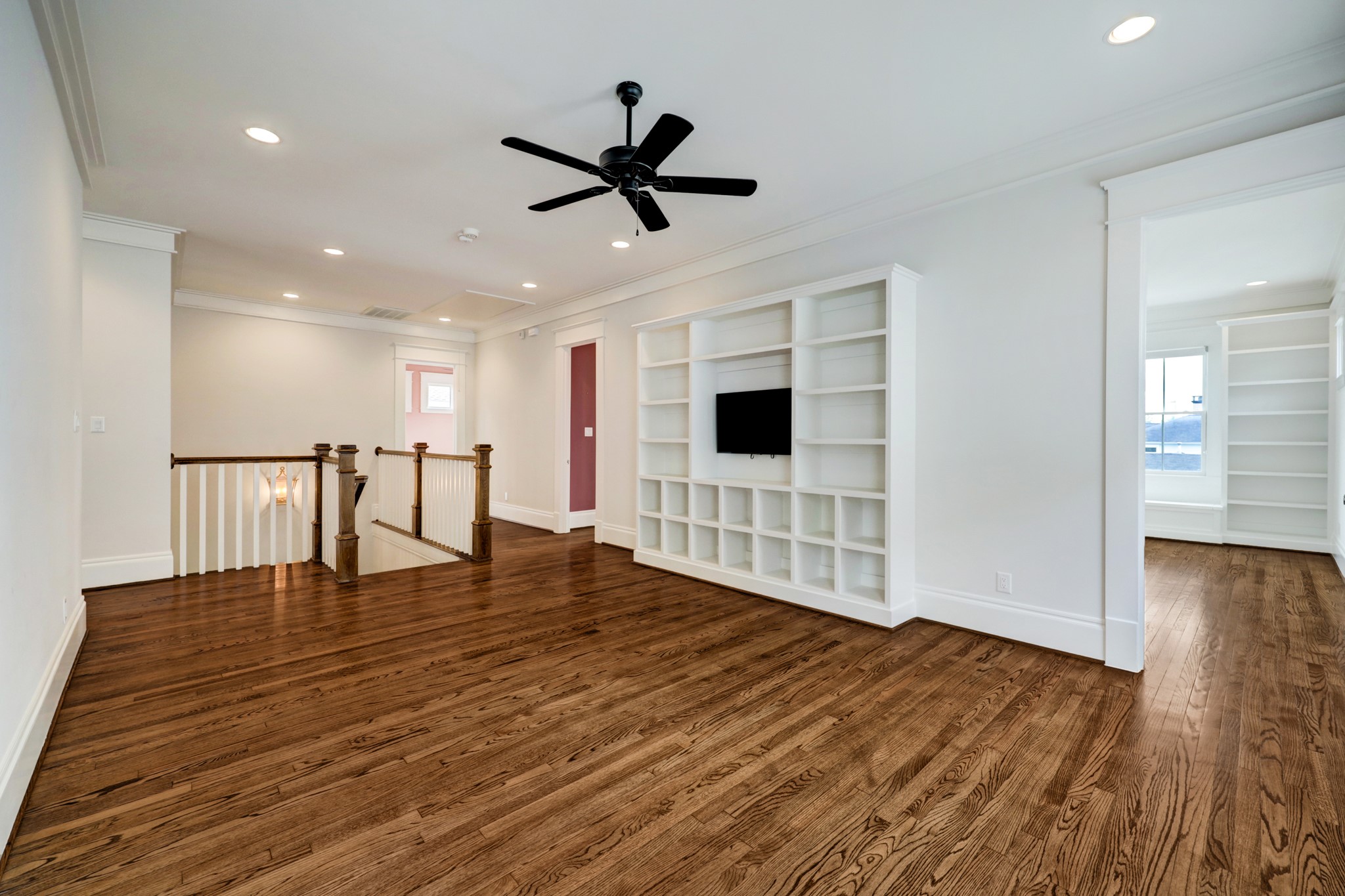 Upstairs, enjoy more living space in the second-floor game room lined by abundant custom shelving with A/V wiring in place.