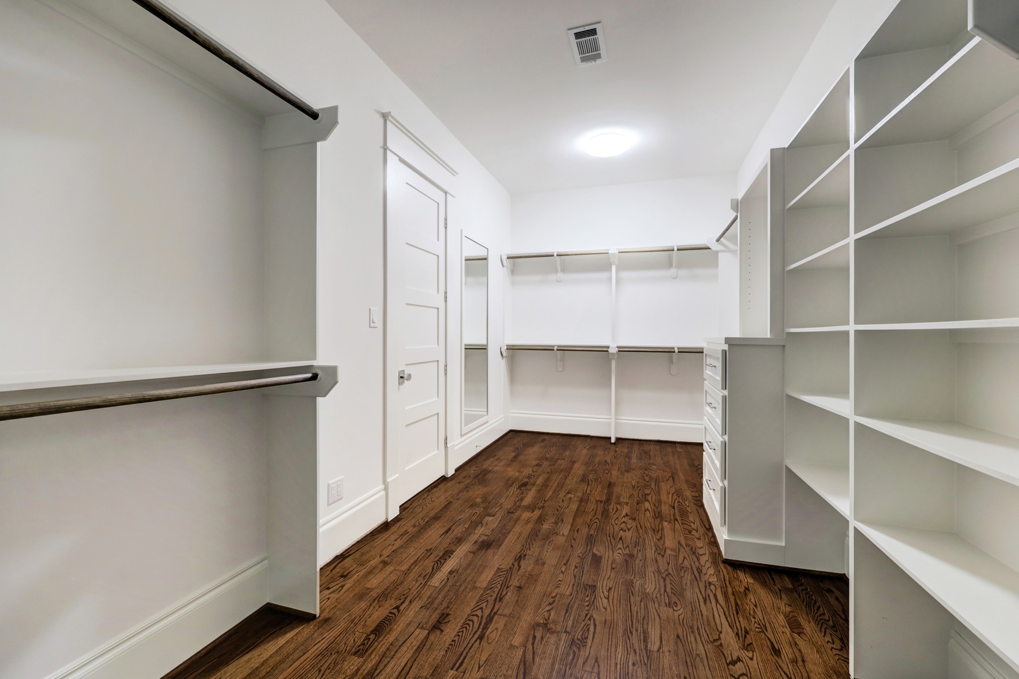 Off the primary bathroom, a palatial walk-in closet tames even the most extensive wardrobe with built-in shelves, hanging rods and drawers.