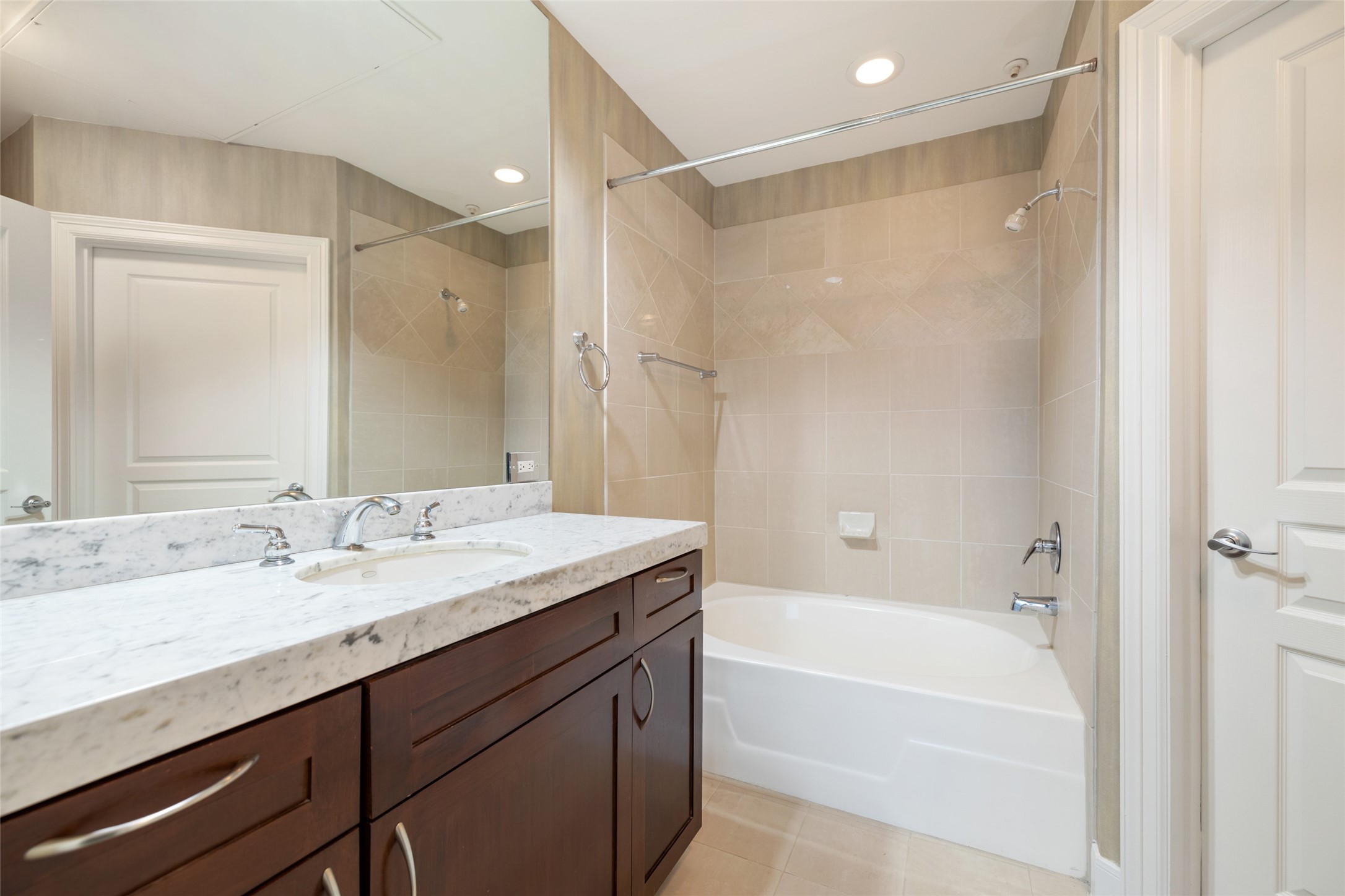 This Bathroom features marble counters, large soaking tub/shower combo, and great storage.