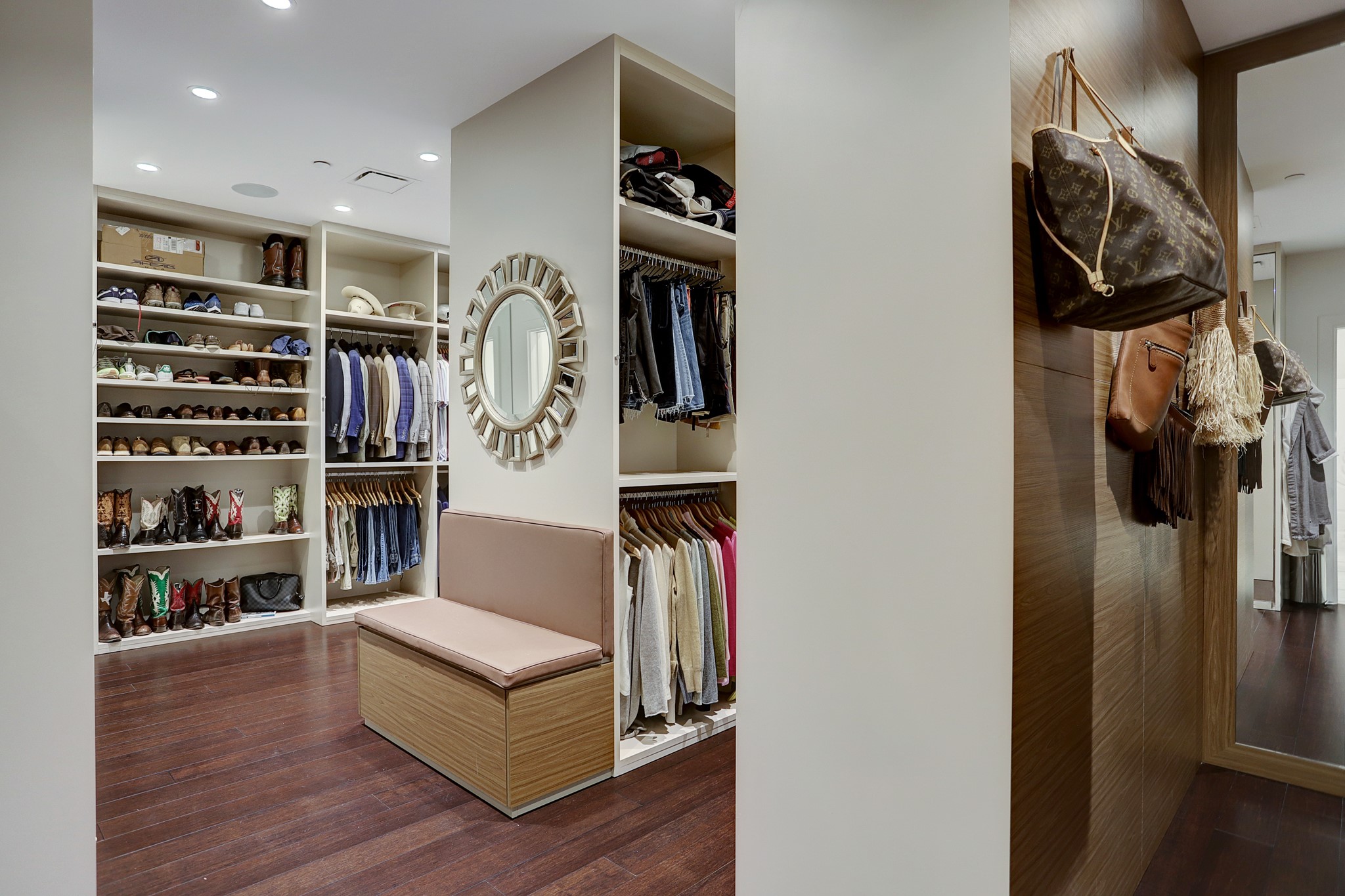Spectacular showroom style Primary closet [20x13] features bamboo floors, leather pulls, built-in bench and ample storage for clothing of all types, shoes and accessories.