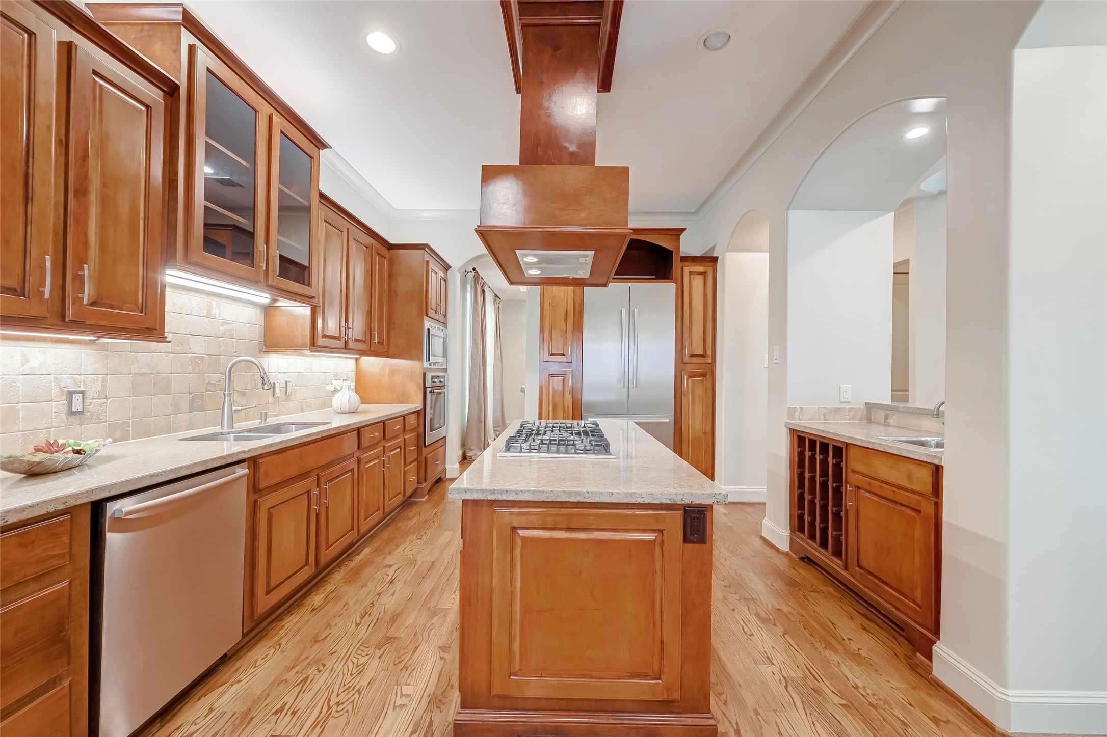 Gourmet style kitchen for an inspiring home-chef. Featuring ample storage in the custom cabinets, Bosh Stainless Steel appliances, granite counters, a 5 burner gas cook top with overhead vent and a wet bar with built-in wine storage.