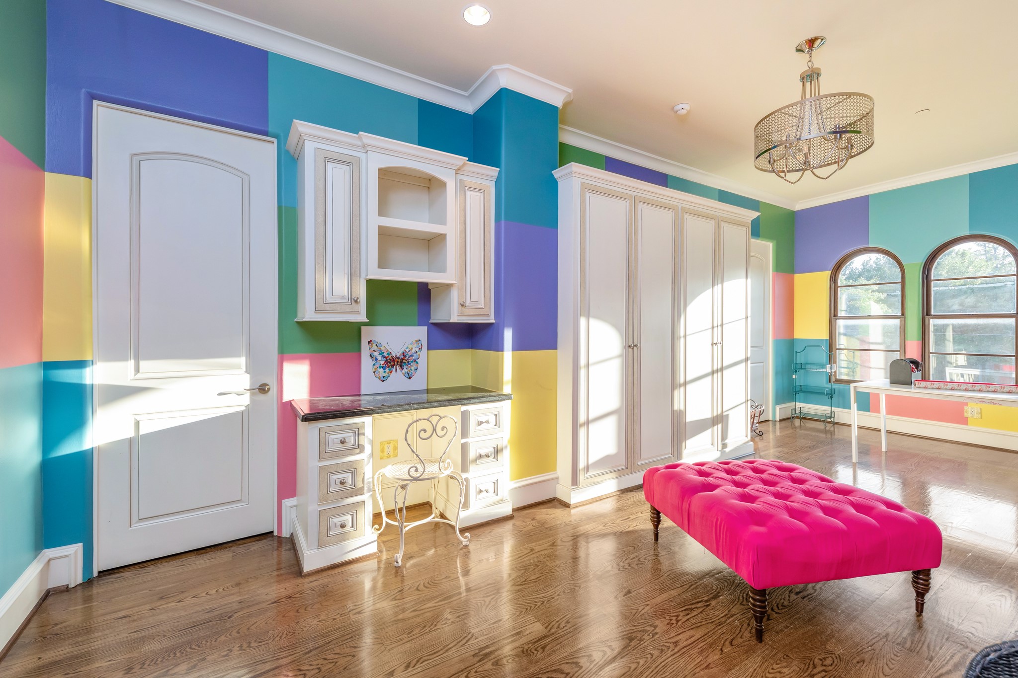 Uniquely thought out room designed for multi-use. Two sitting areas can be used for school work or crafts, room includes ample custom built-ins, custom paint details, three arched windows. On each side of the room you will find two additional ensuite bedrooms (nanny quarters).