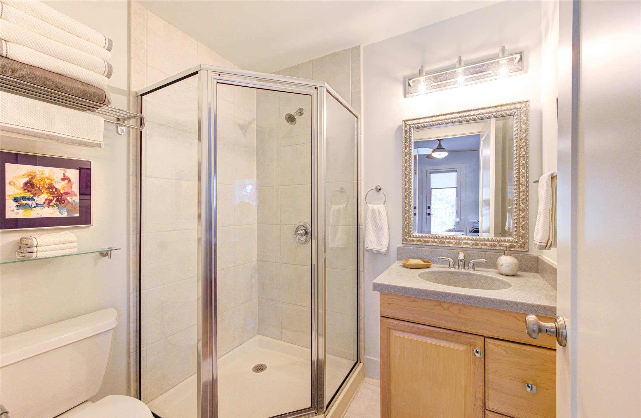 This bathroom boasts a walk-in shower and modern lighting.