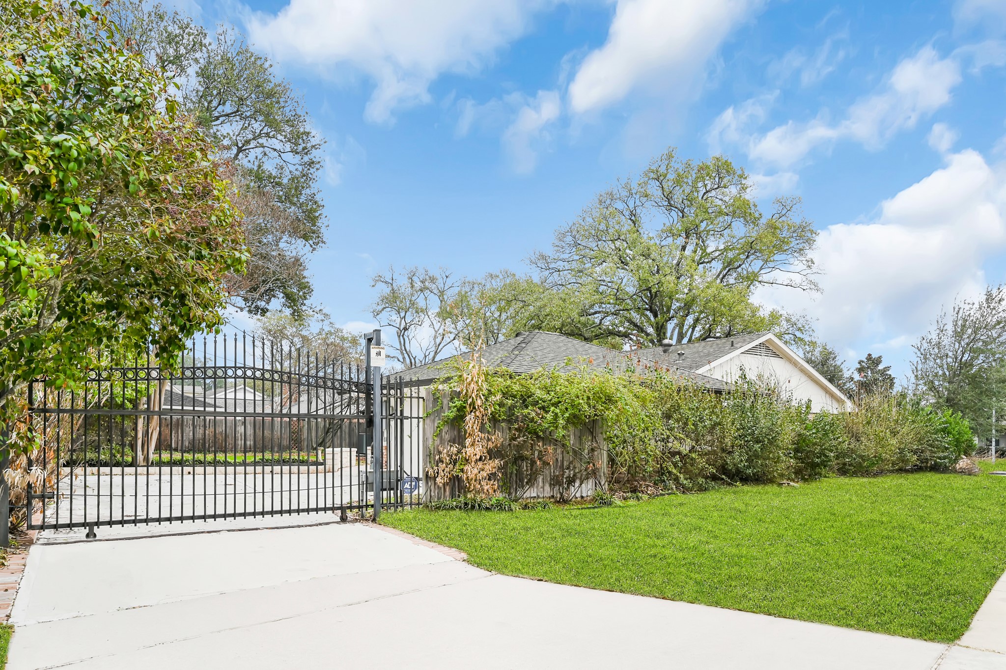 THE GATED DRIVEWAY IS LOCATED ON THE SIDE OF THE HOME.